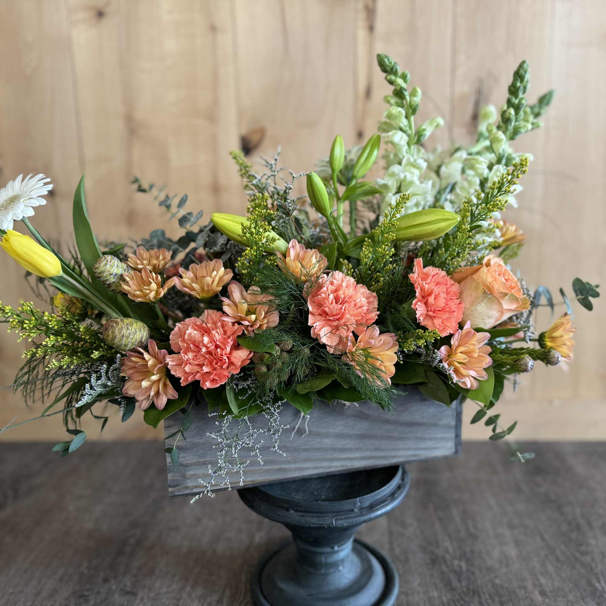 Mixed bouquet in a rectangular wooden container with peach and white blooms