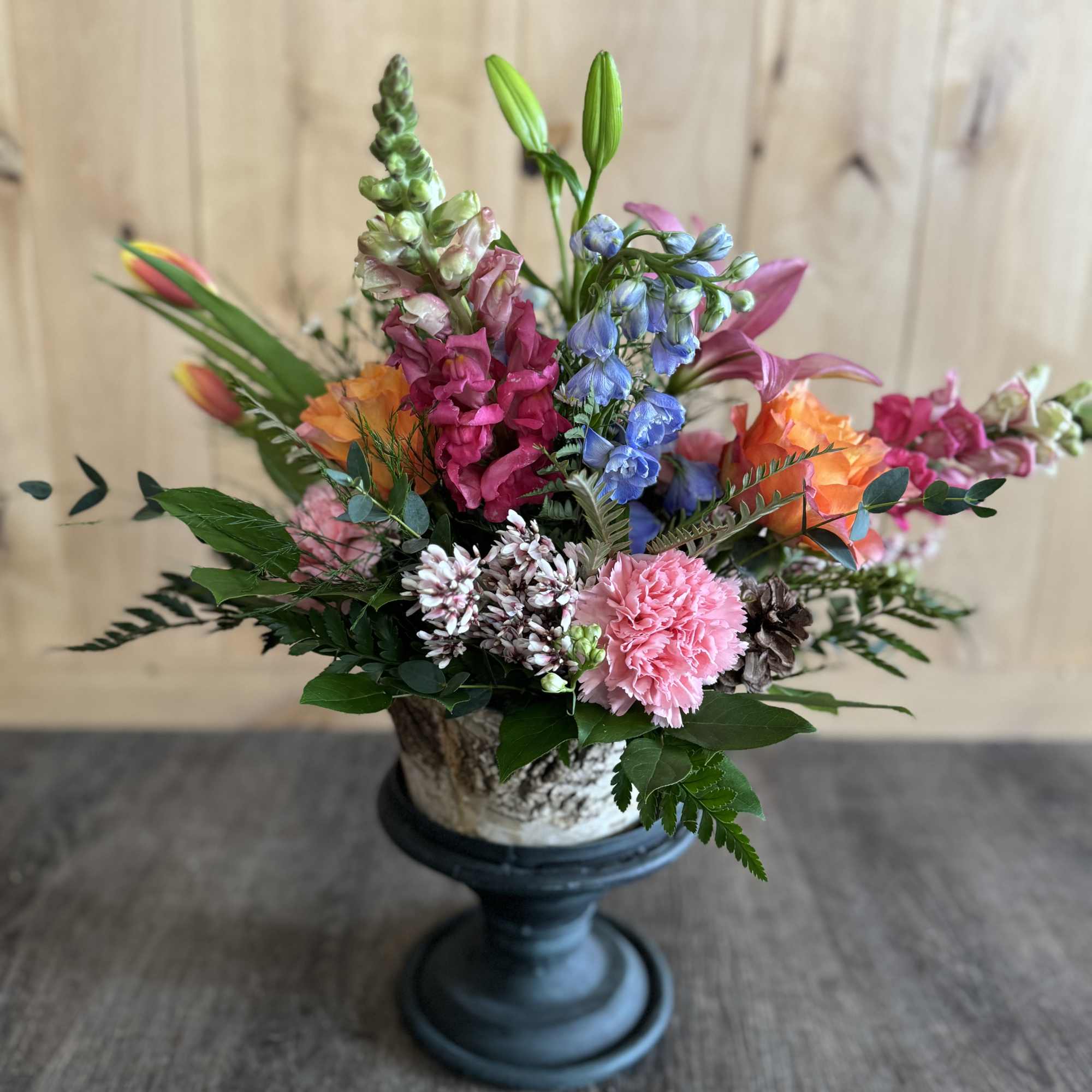 Colorful mixed flower arrangement in a pedestal vase