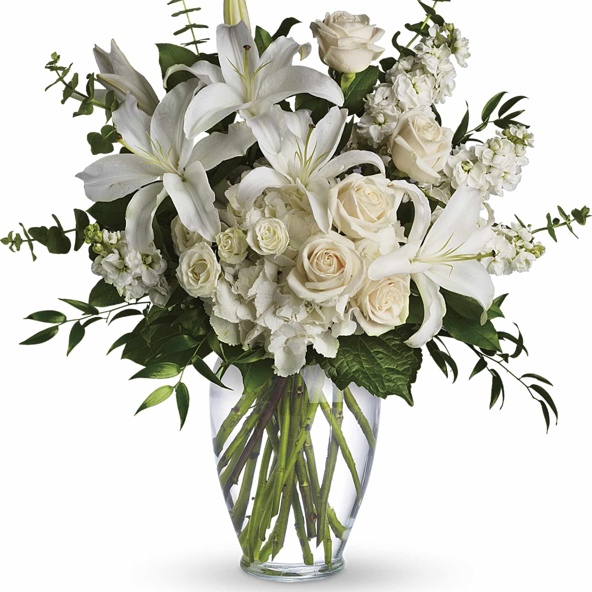 White lilies and roses arranged in a clear glass vase