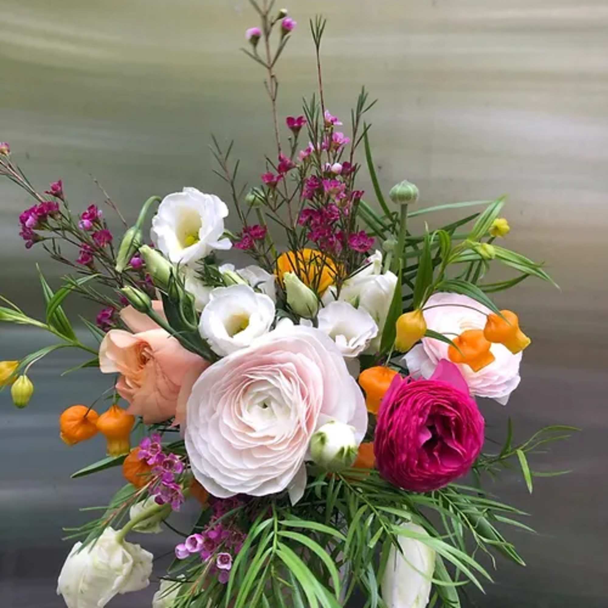 Mixed bouquet with pale pink, white, orange, and magenta flowers