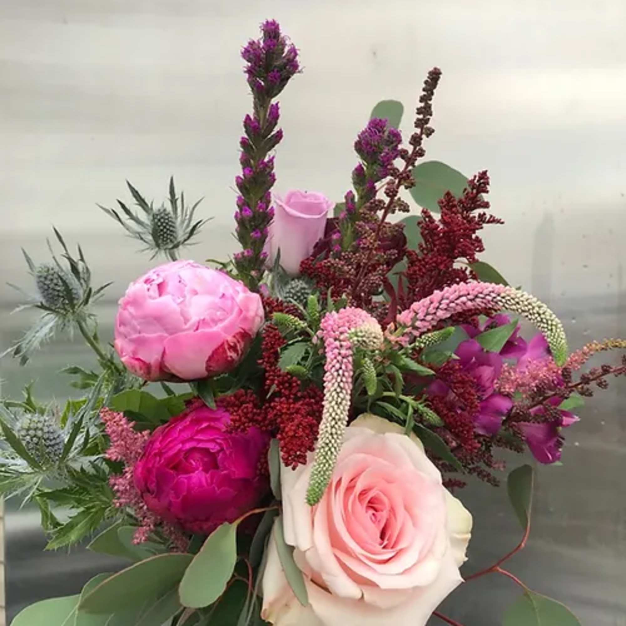 Bouquet of pink and purple flowers with eucalyptus foliage