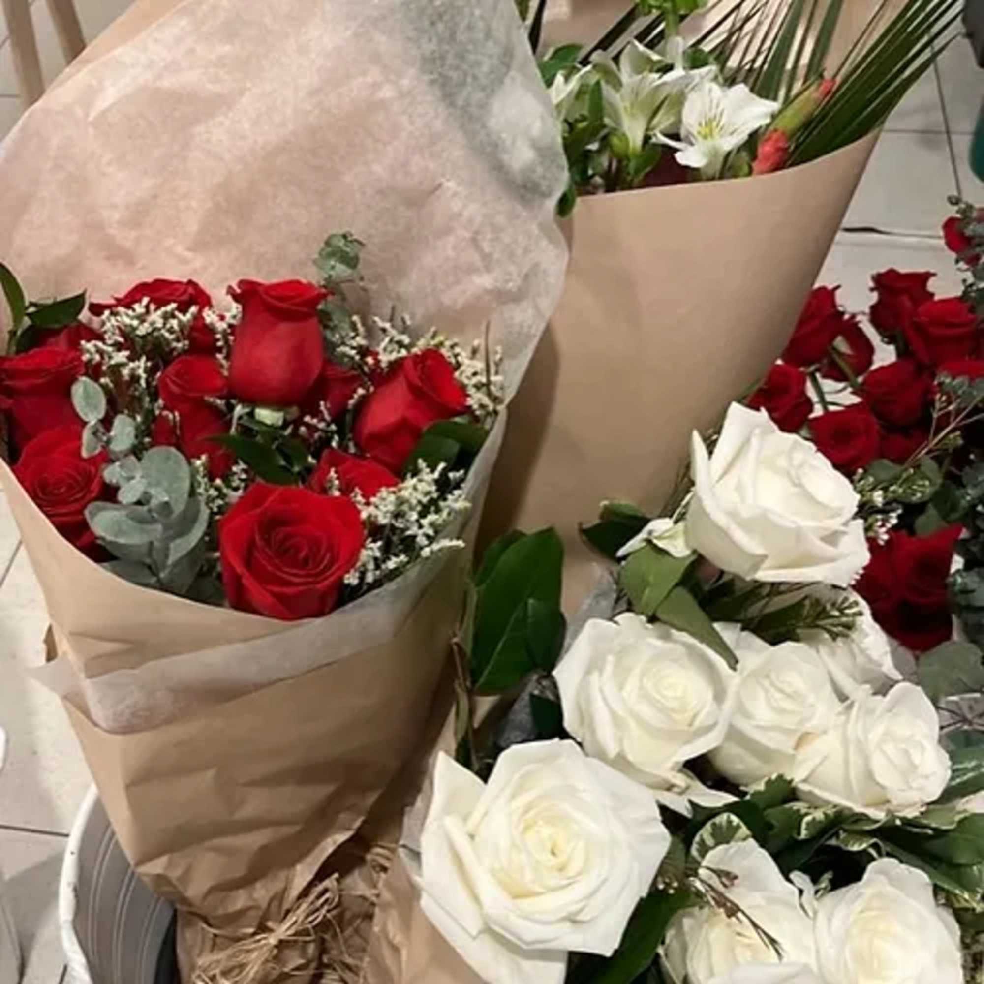 Bouquets of red and white roses wrapped in brown paper