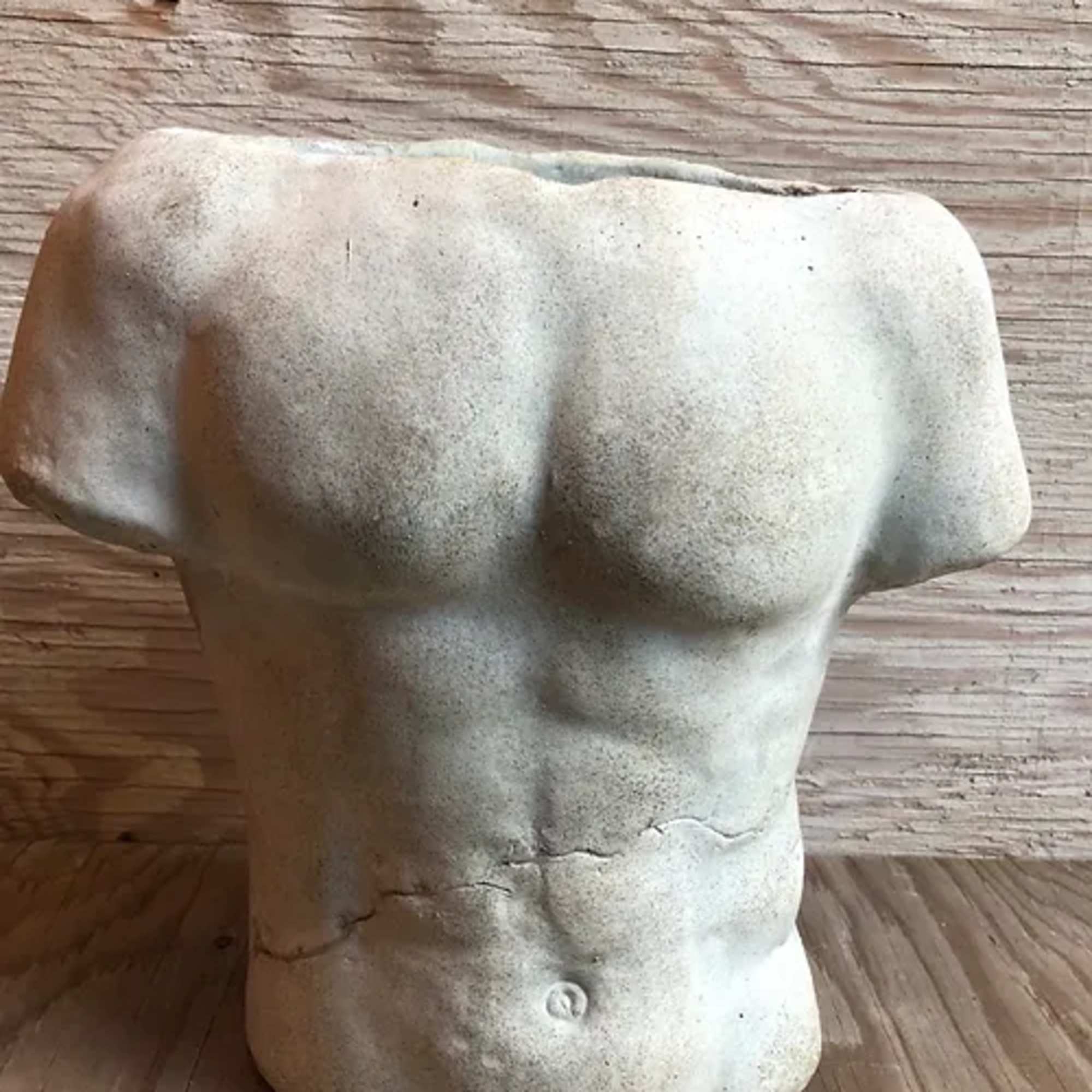 Torso-shaped concrete planter on a wooden surface