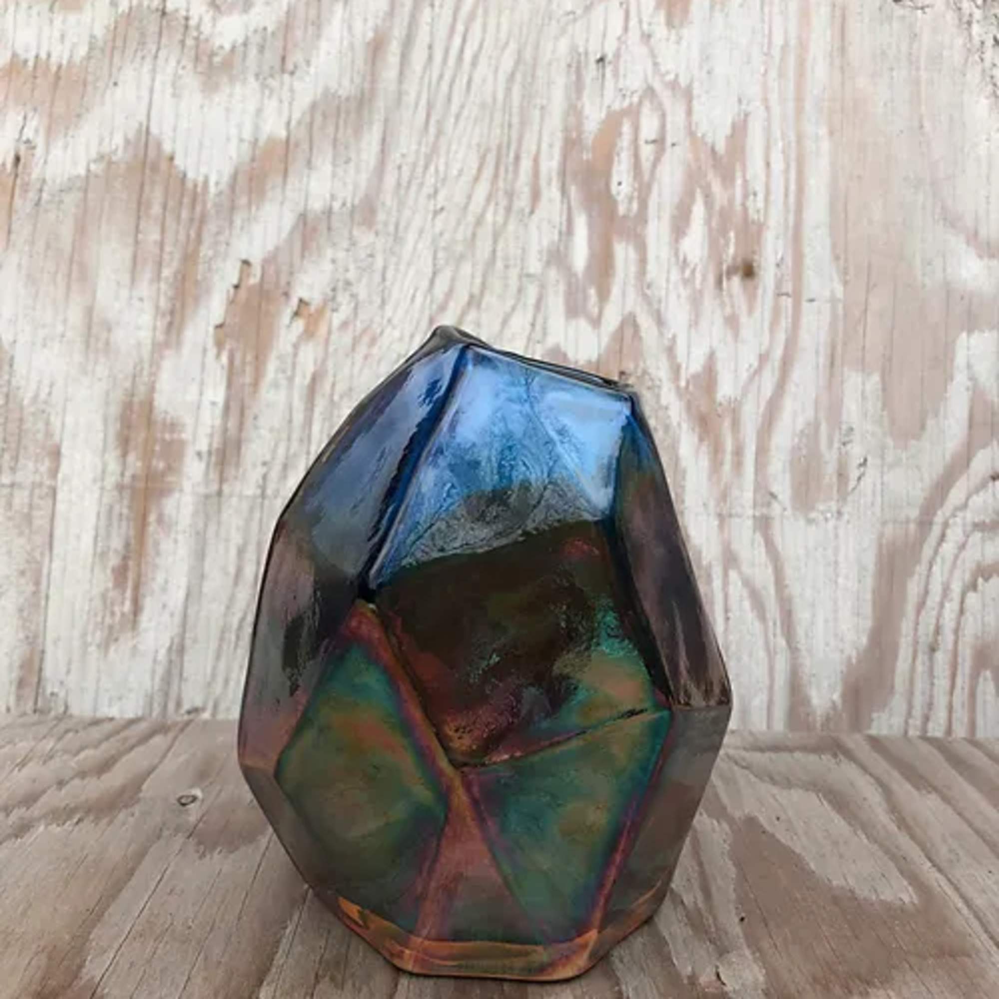 Iridescent faceted decorative stone on a wooden surface