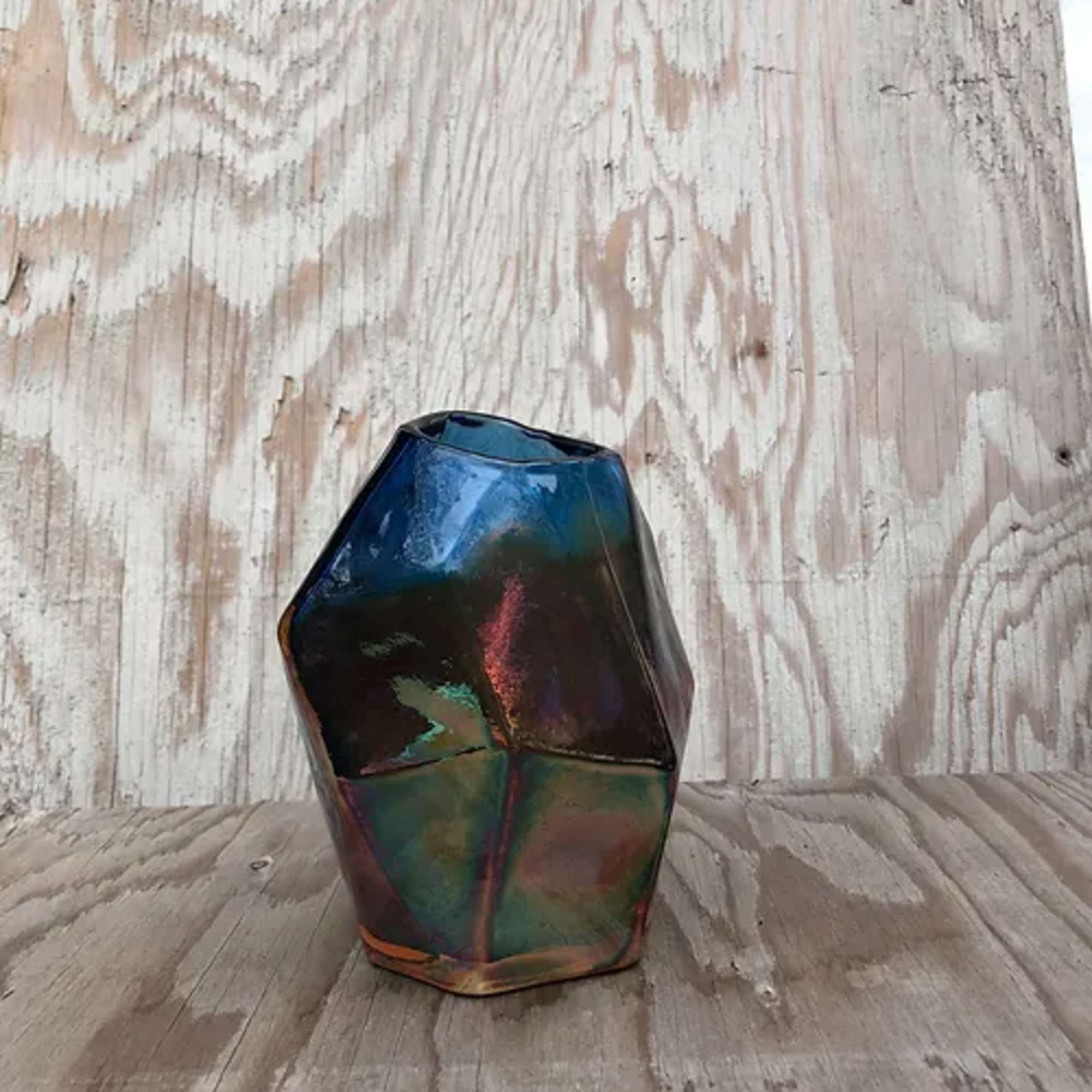 Iridescent geometric glass vase on a wooden surface
