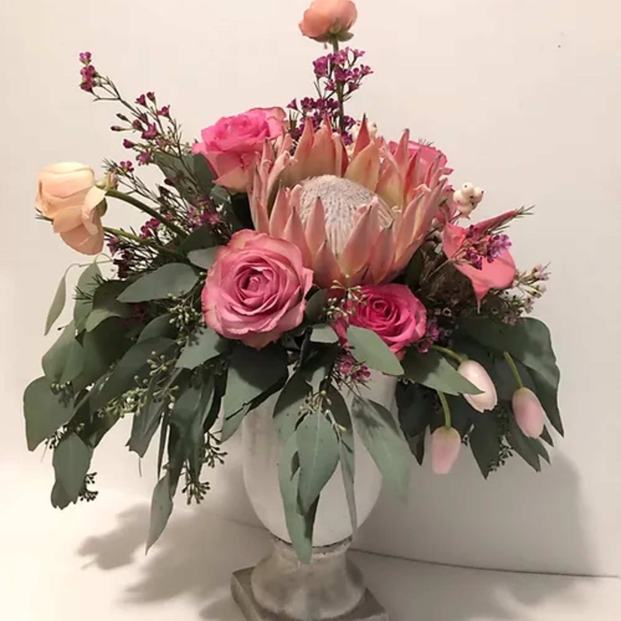 Pink and peach floral arrangement in a white vase