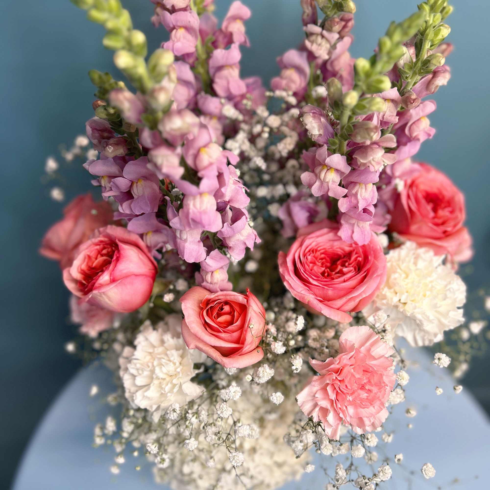 Pink roses and carnations with lavender snapdragons in a bouquet