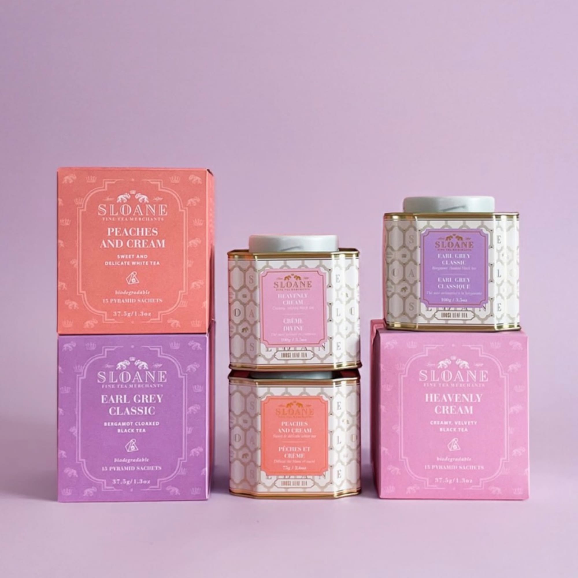 Assorted Sloane tea tins and boxes arranged on a pink background