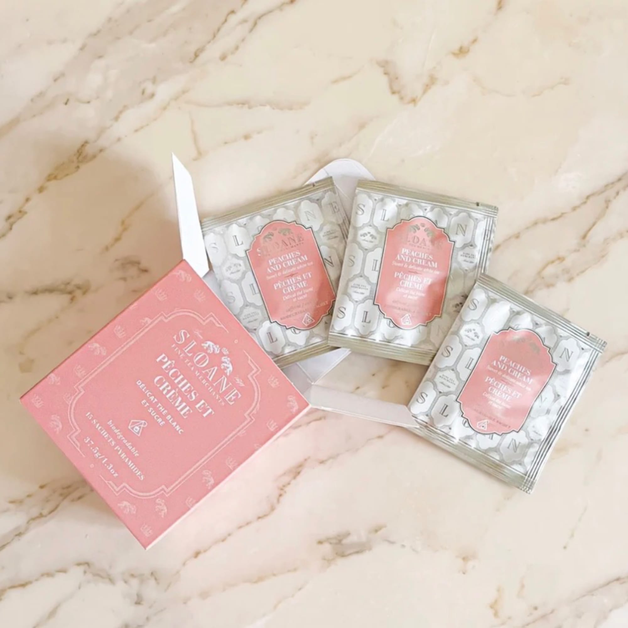 Pink and silver packaged candy boxes on a marble surface