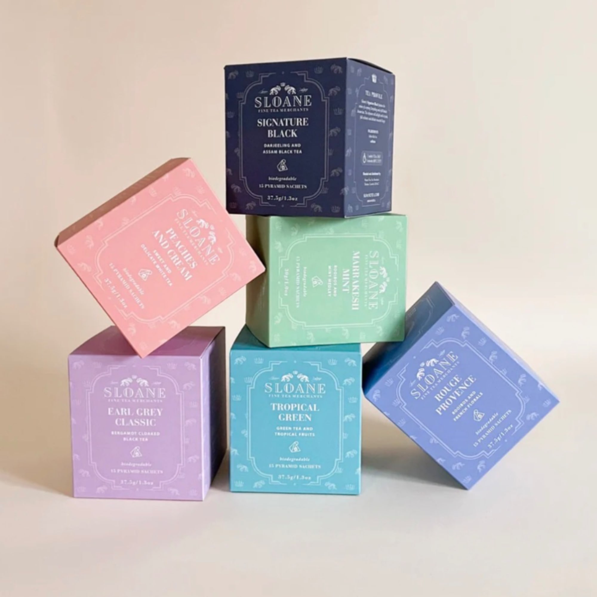 Stacked pastel tea boxes in pink, purple, blue, green, and navy