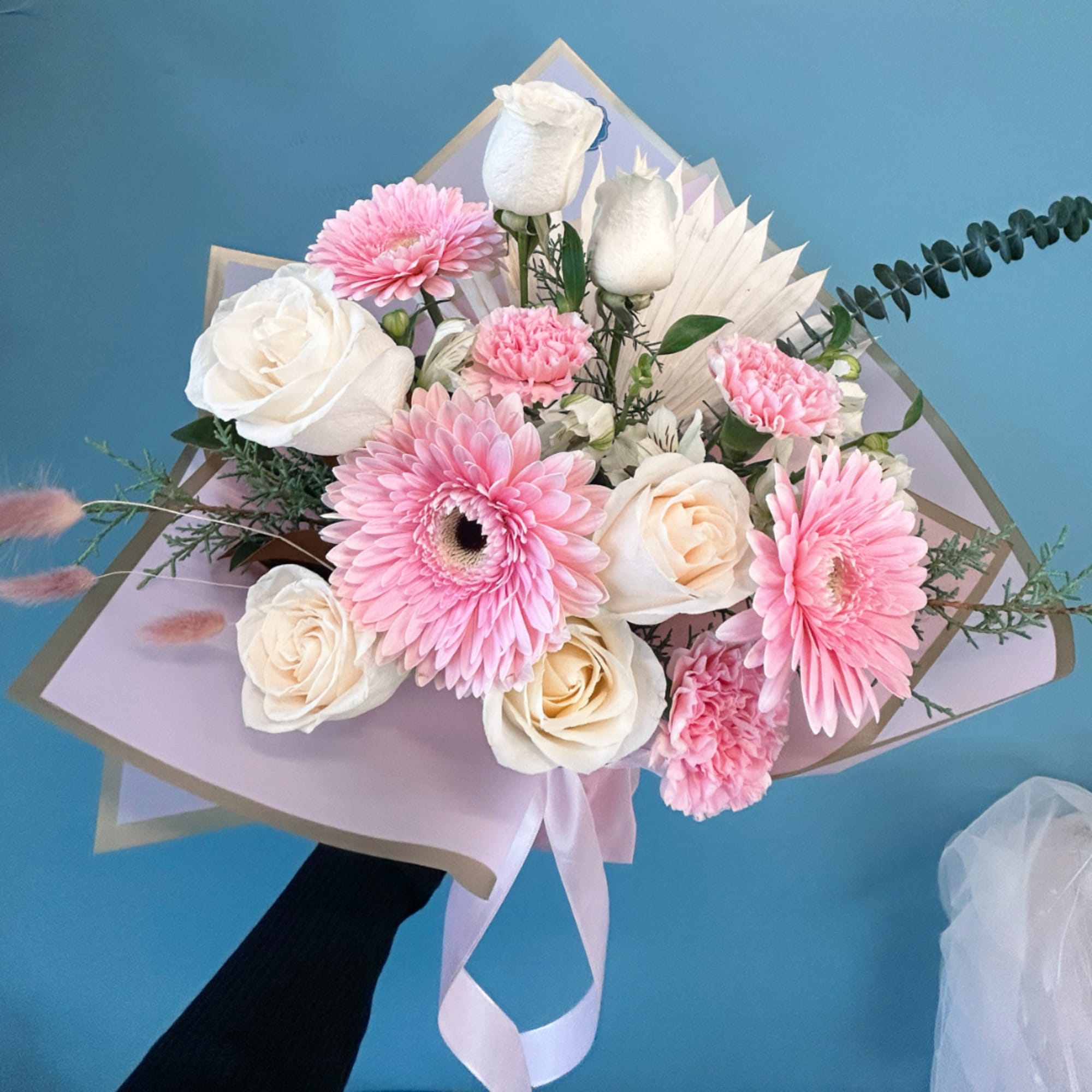 Pink and white bouquet with roses and gerbera daisies wrapped in pastel paper