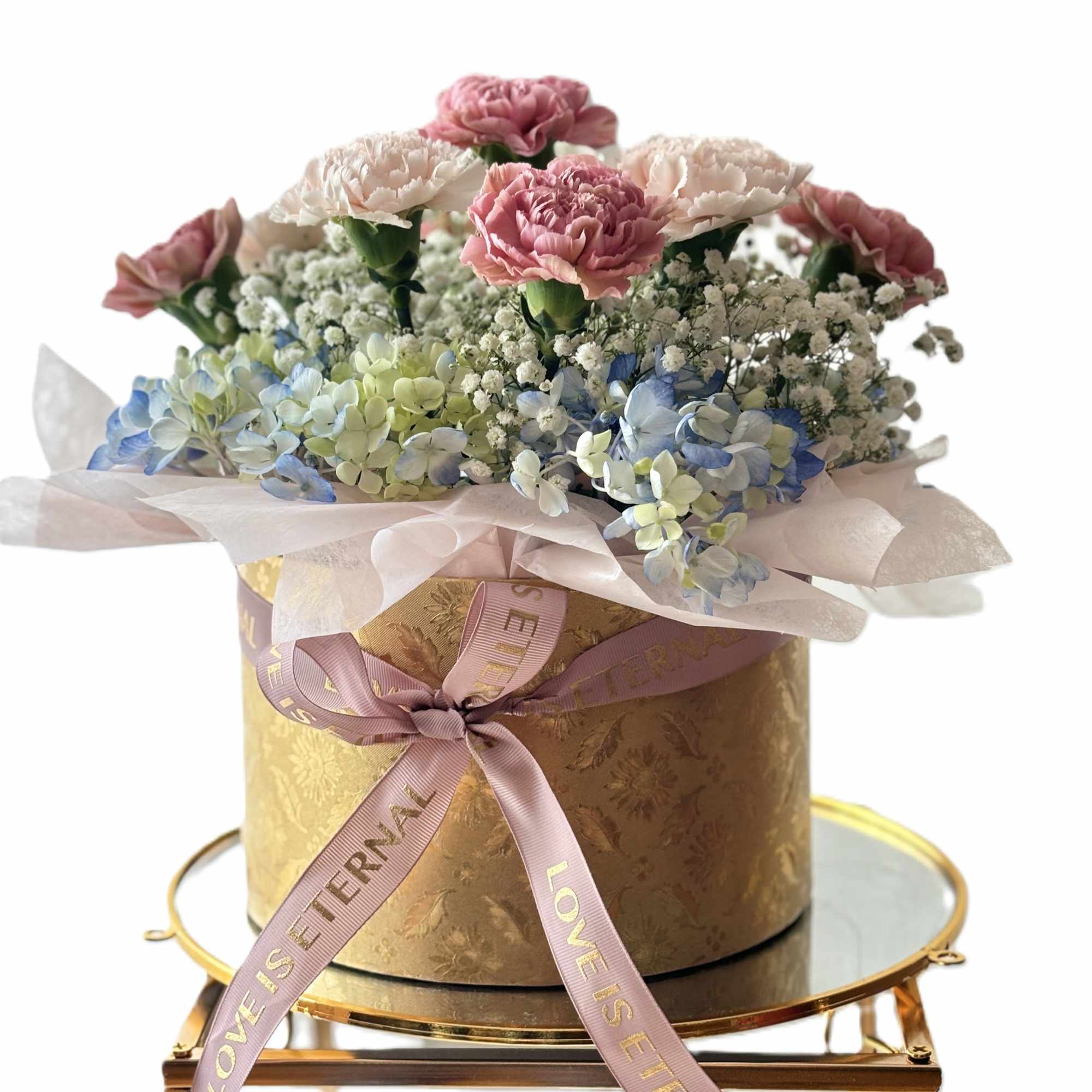 Pink and white carnations with blue hydrangeas in a gold hatbox, photo 2 of 3