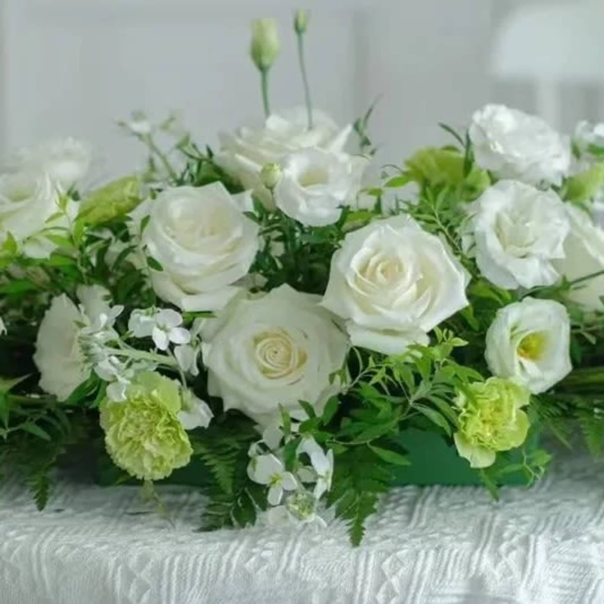White rose and lisianthus casket spray with green accents