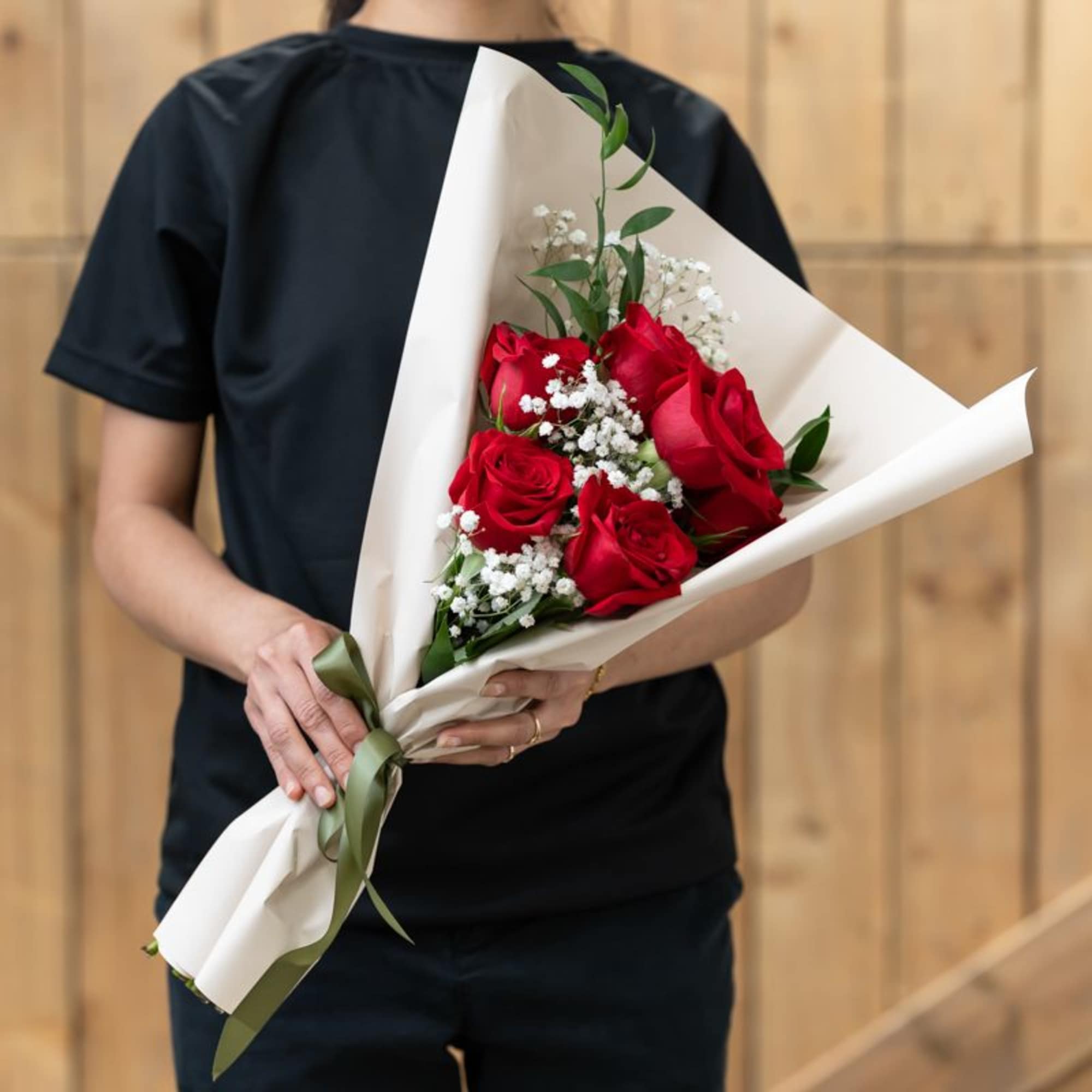 Bouquet of red roses with baby's breath in white paper wrap