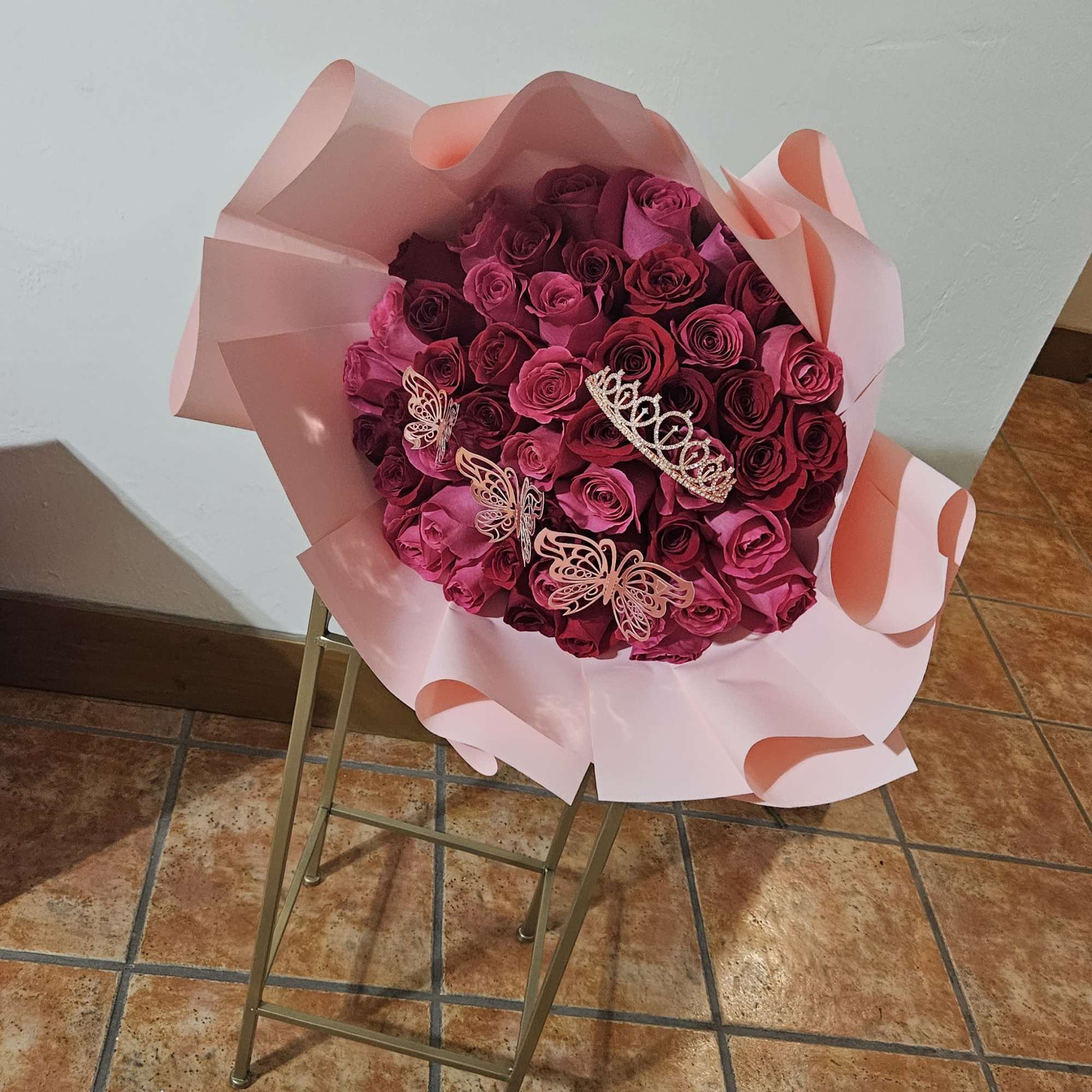 Bouquet of pink and magenta roses wrapped in pale pink paper