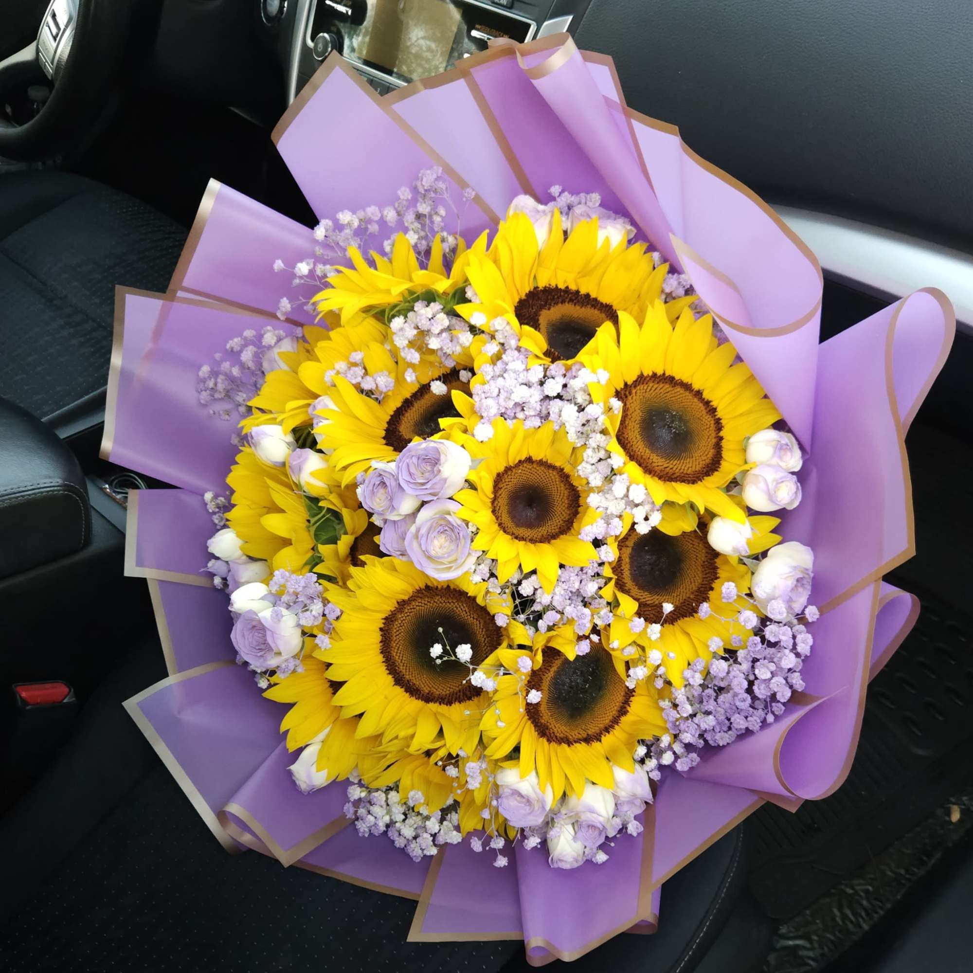 Golden sunflowers, lavender roses and white and lilac baby&rsquo;s breath create a, photo 2 of 2