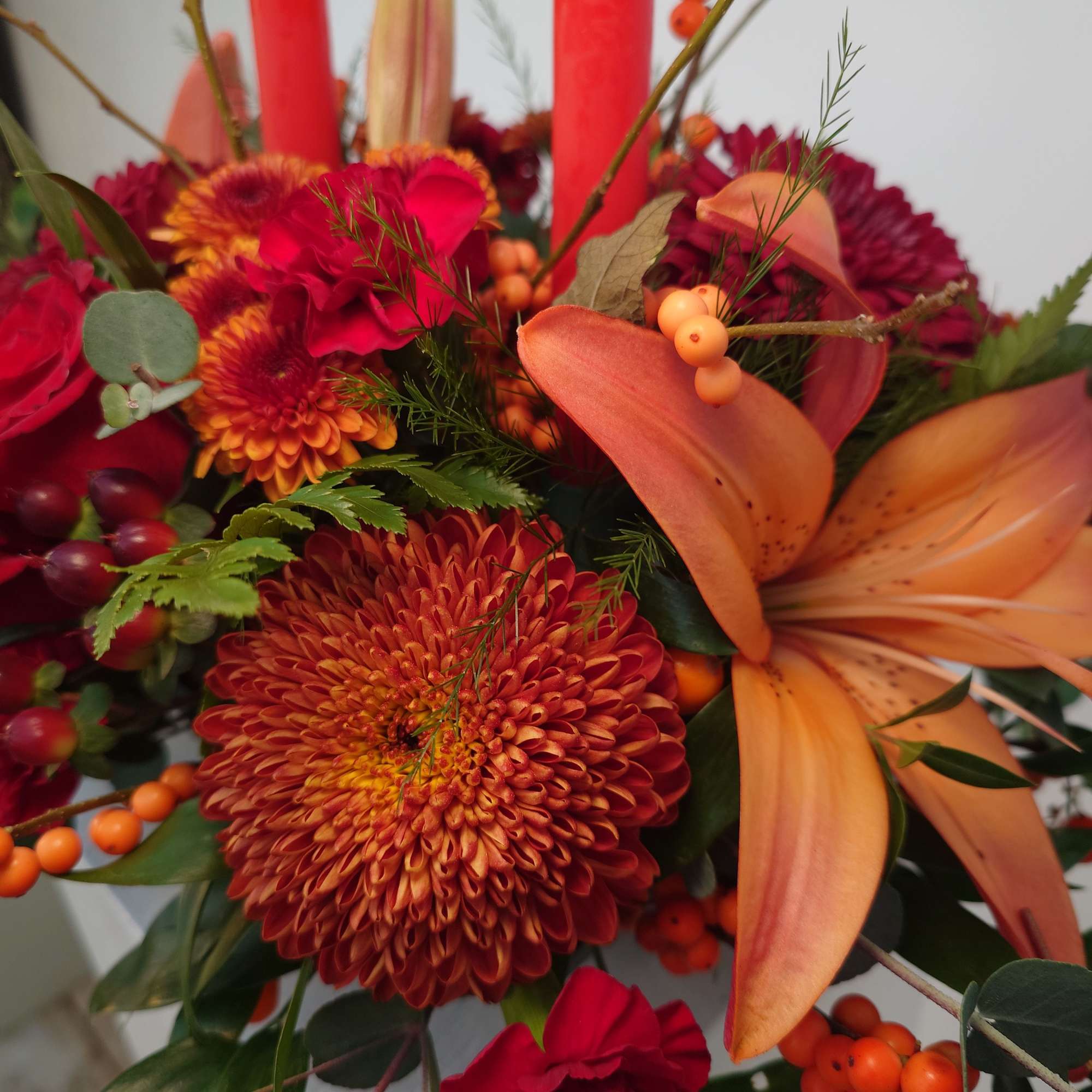 Orange lilies and red chrysanthemums in a mixed bouquet