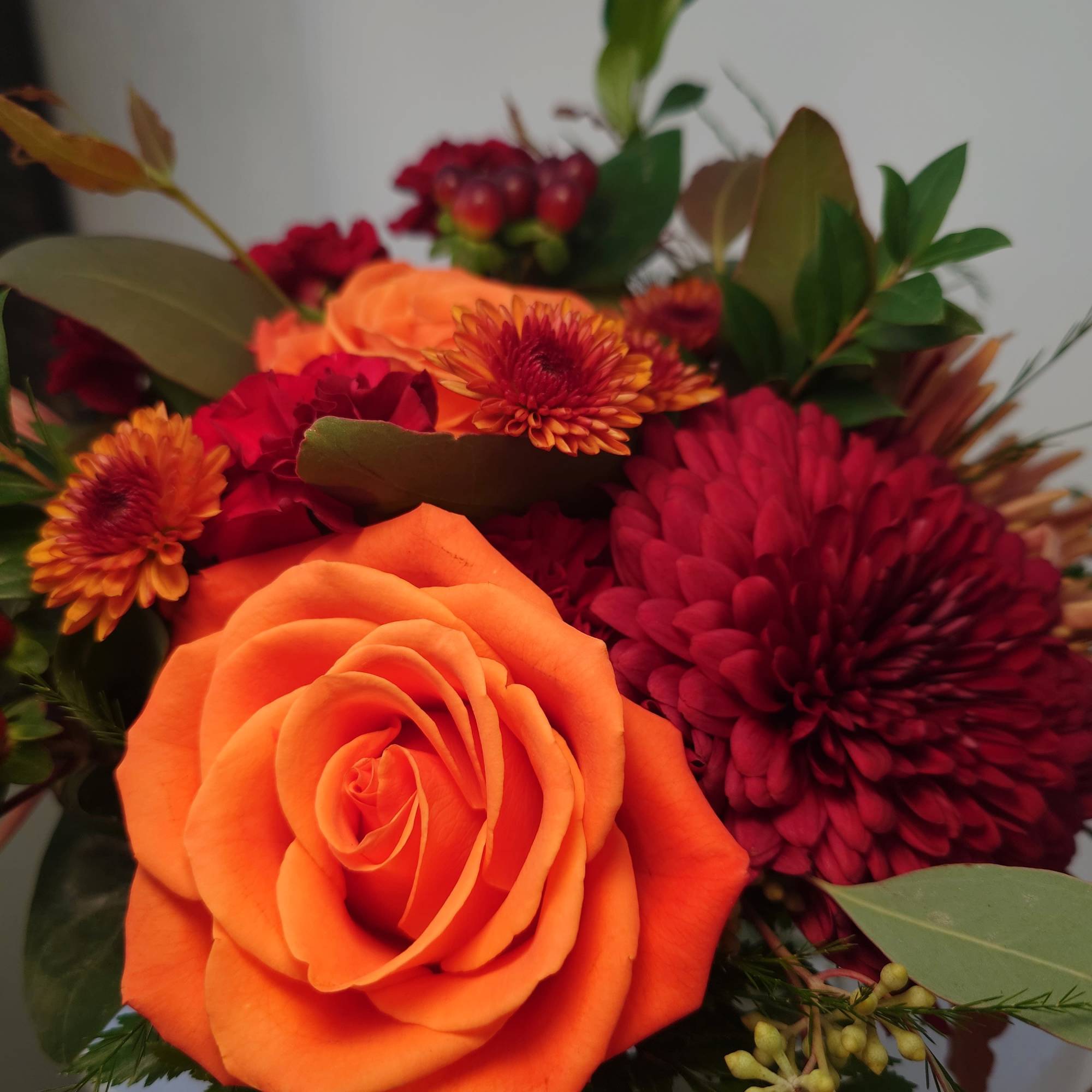 Bouquet with an orange rose and burgundy chrysanthemums