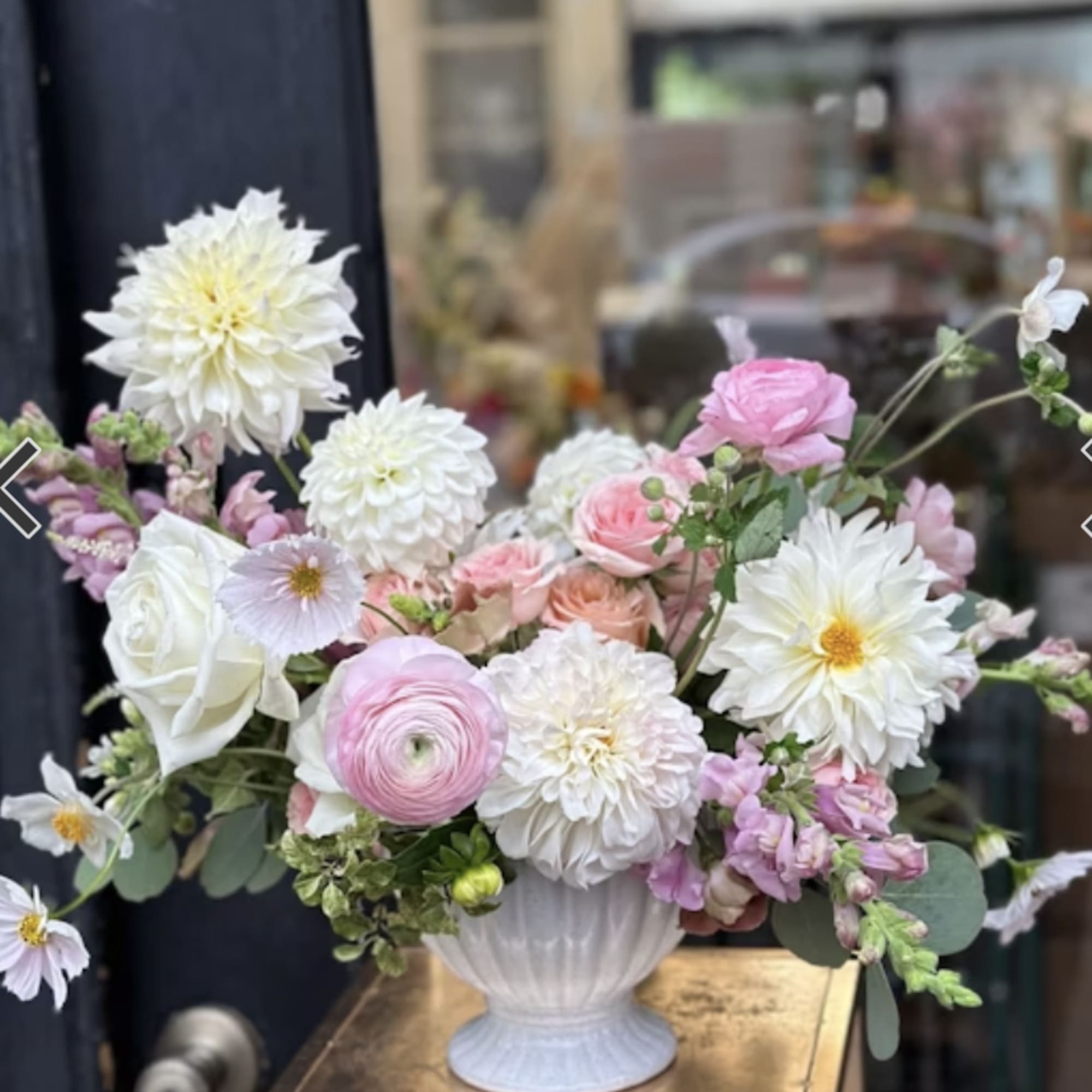 Pastel bouquet of white and pink flowers in a white vase