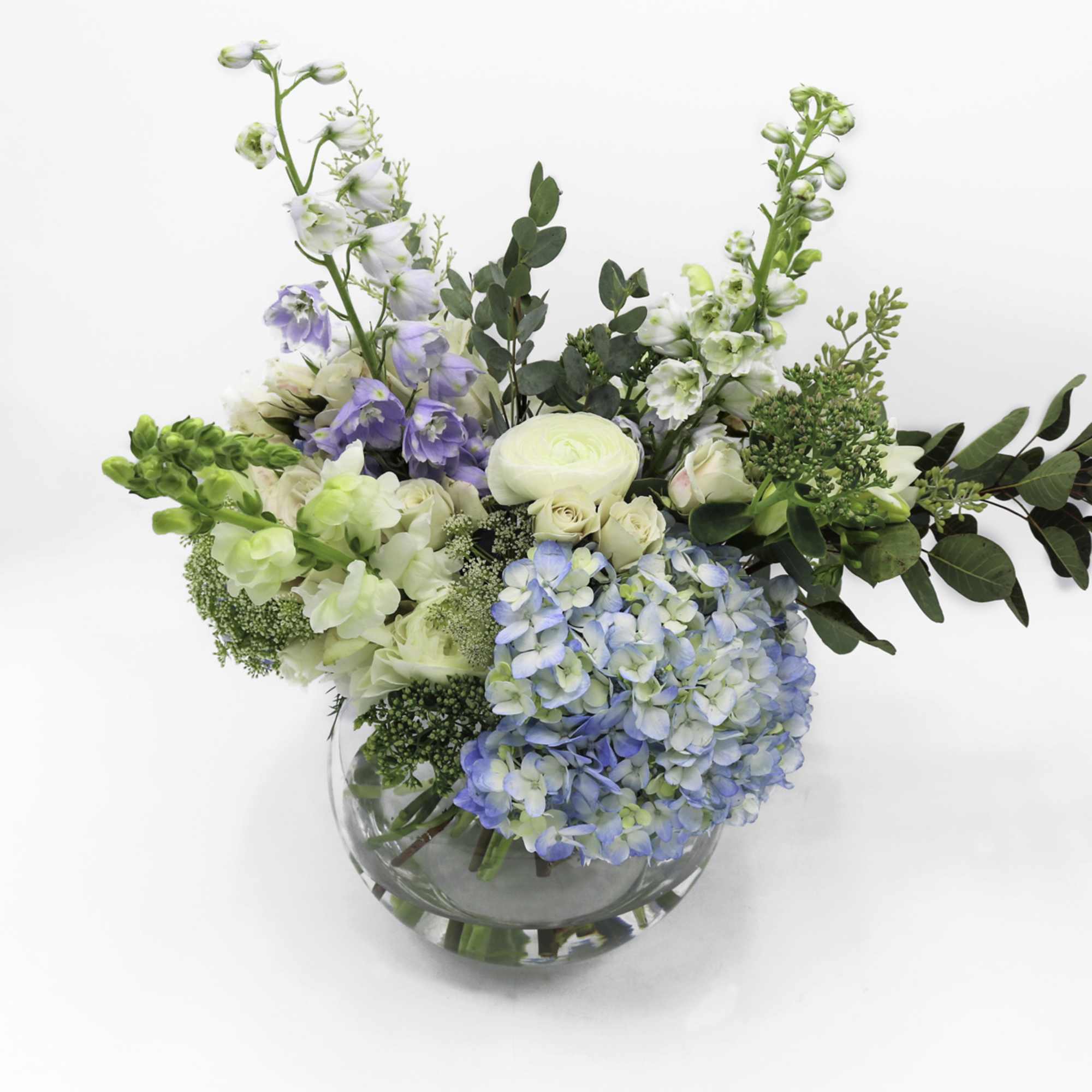 Mixed pastel flowers in a clear glass vase