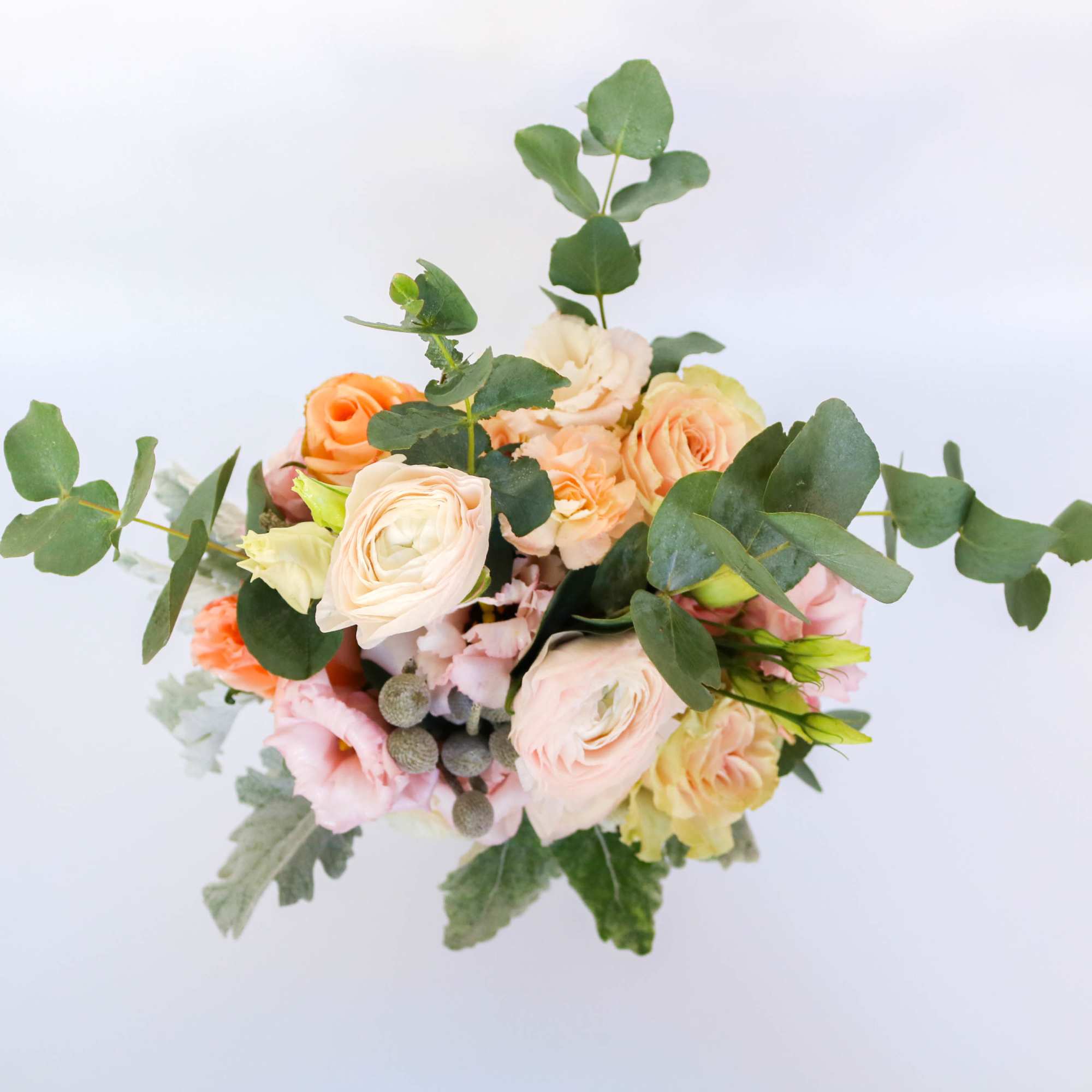 Bouquet of peach and pink flowers with eucalyptus greenery