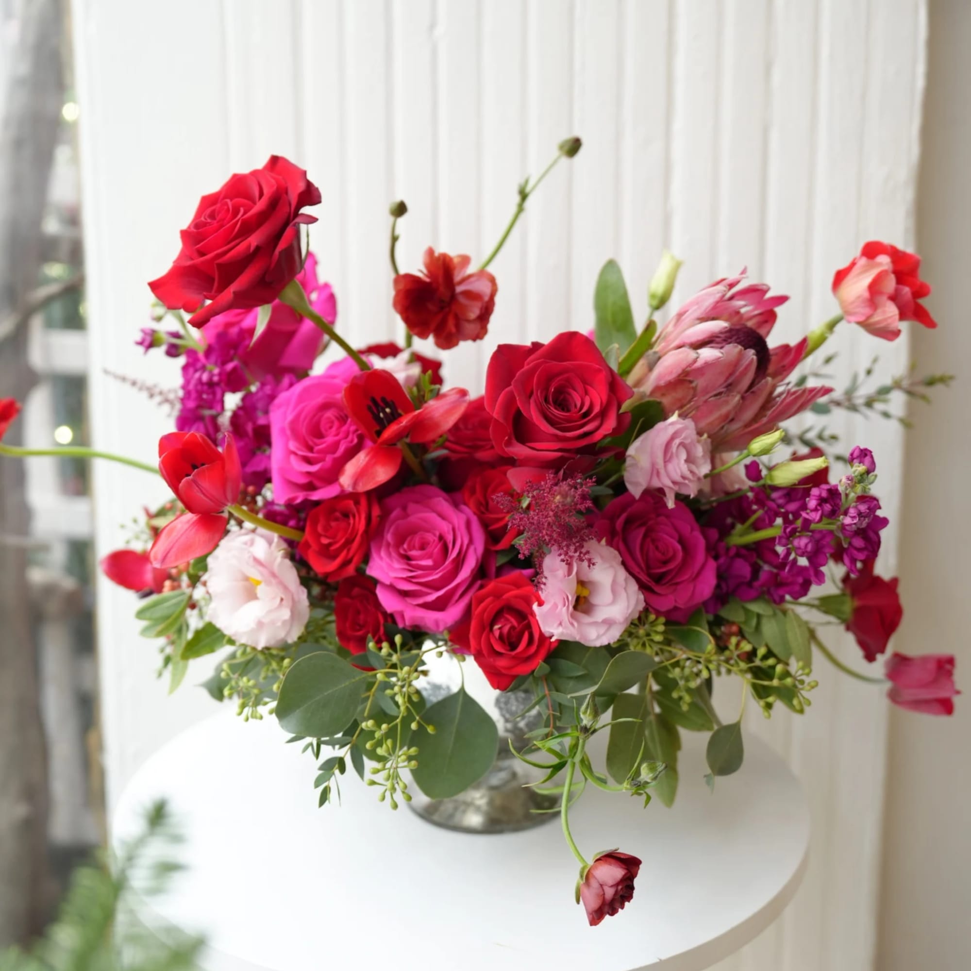 Mixed bouquet of red and pink roses in a glass vase
