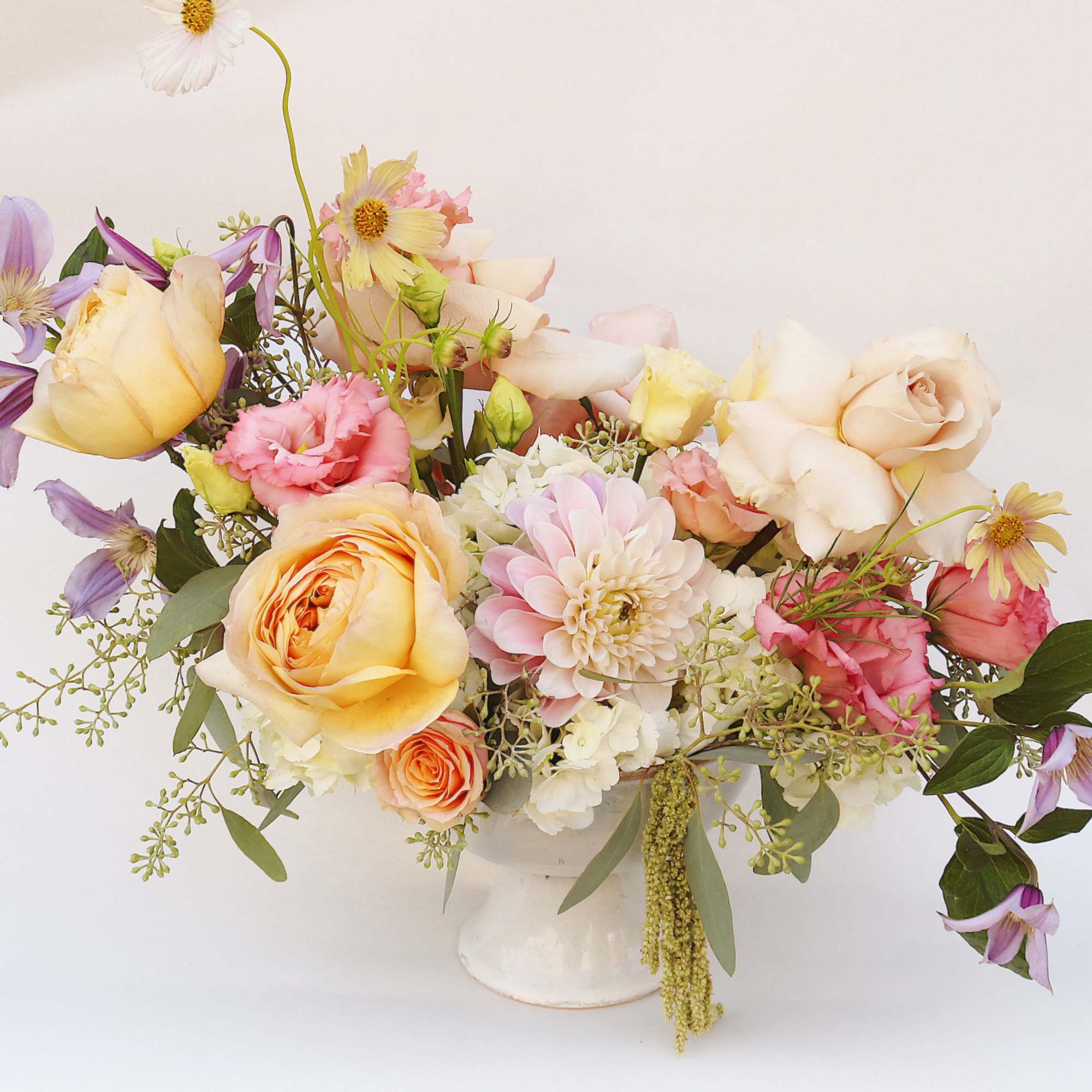 Mixed pastel flower arrangement in a white vase