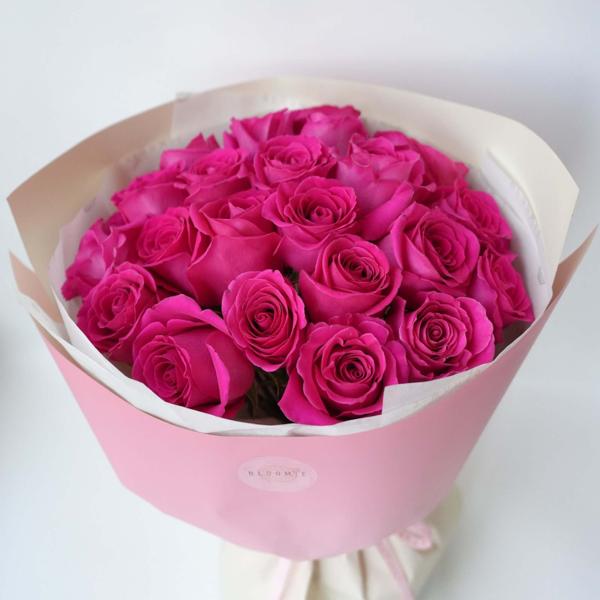Bouquet of bright pink roses wrapped in pink paper