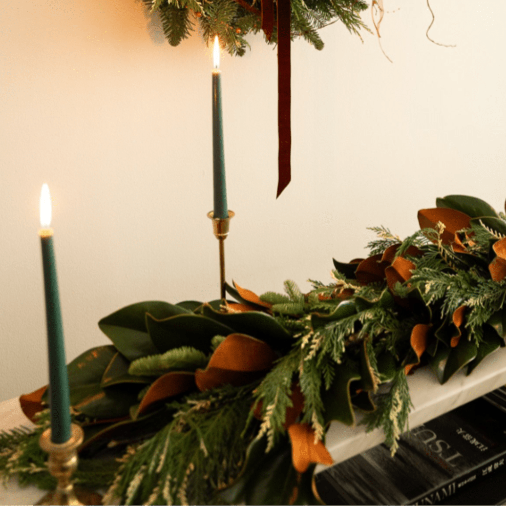 Long evergreen garland with candles on a mantel