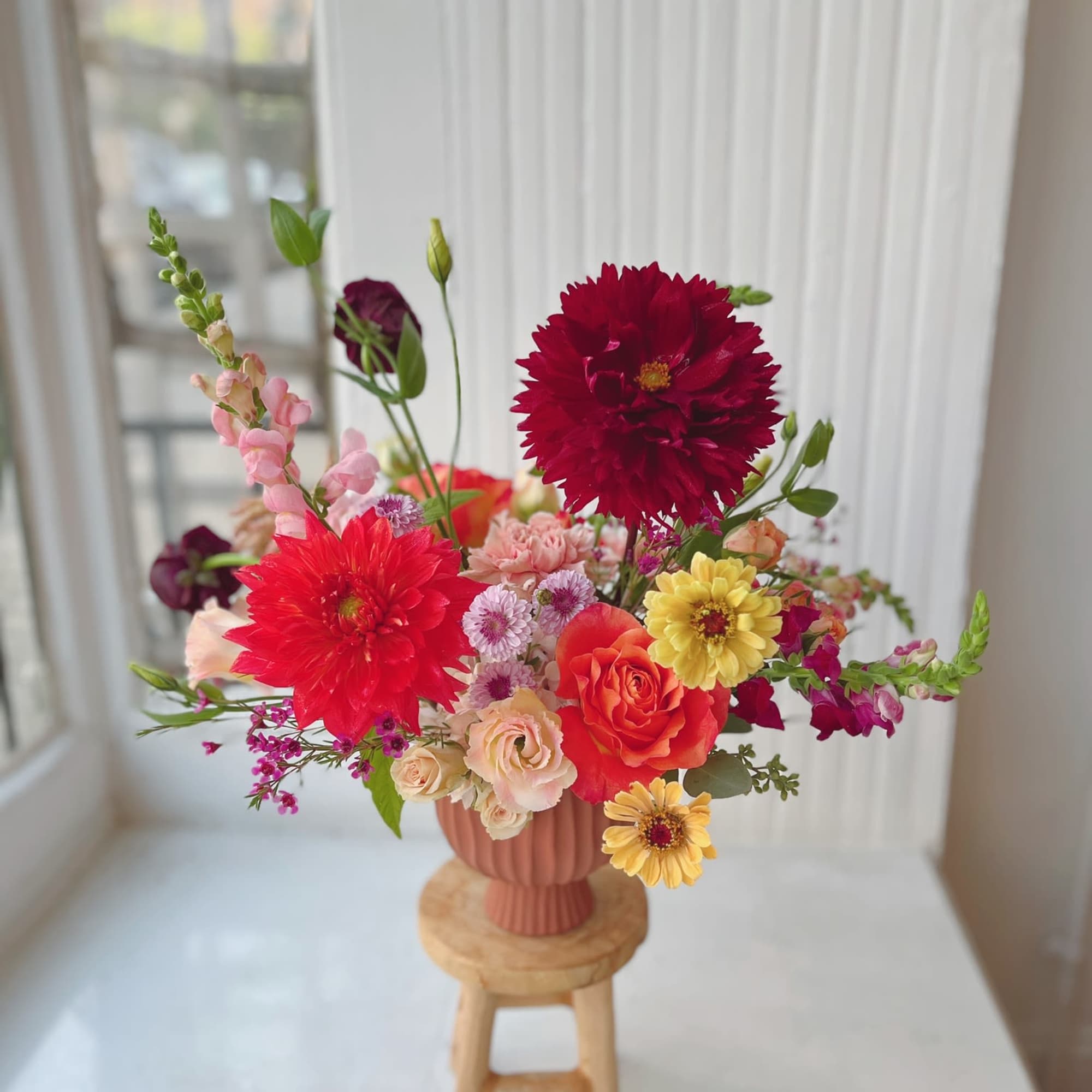 Mixed bouquet of bright flowers in a pink vase