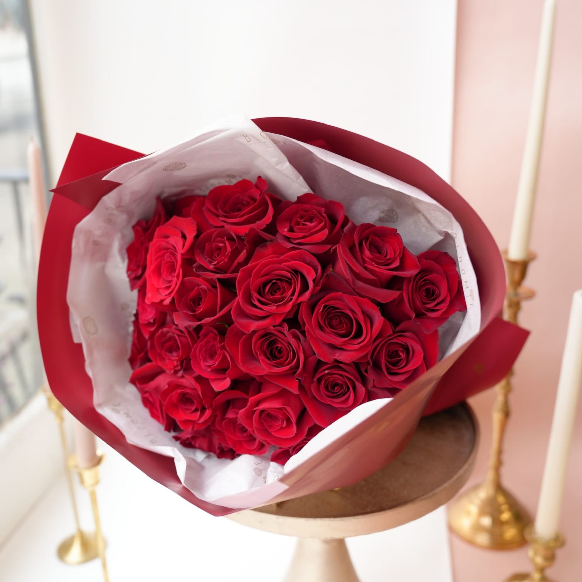 Bouquet of red roses wrapped in red and white paper