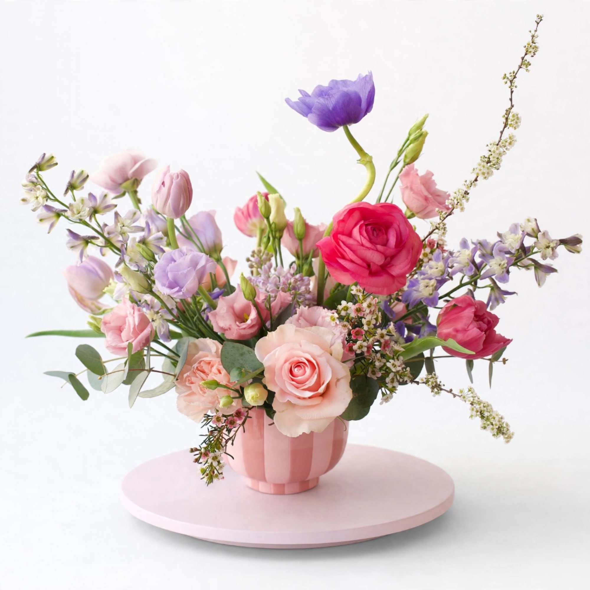 Pink and purple mixed flower arrangement in a pink vase