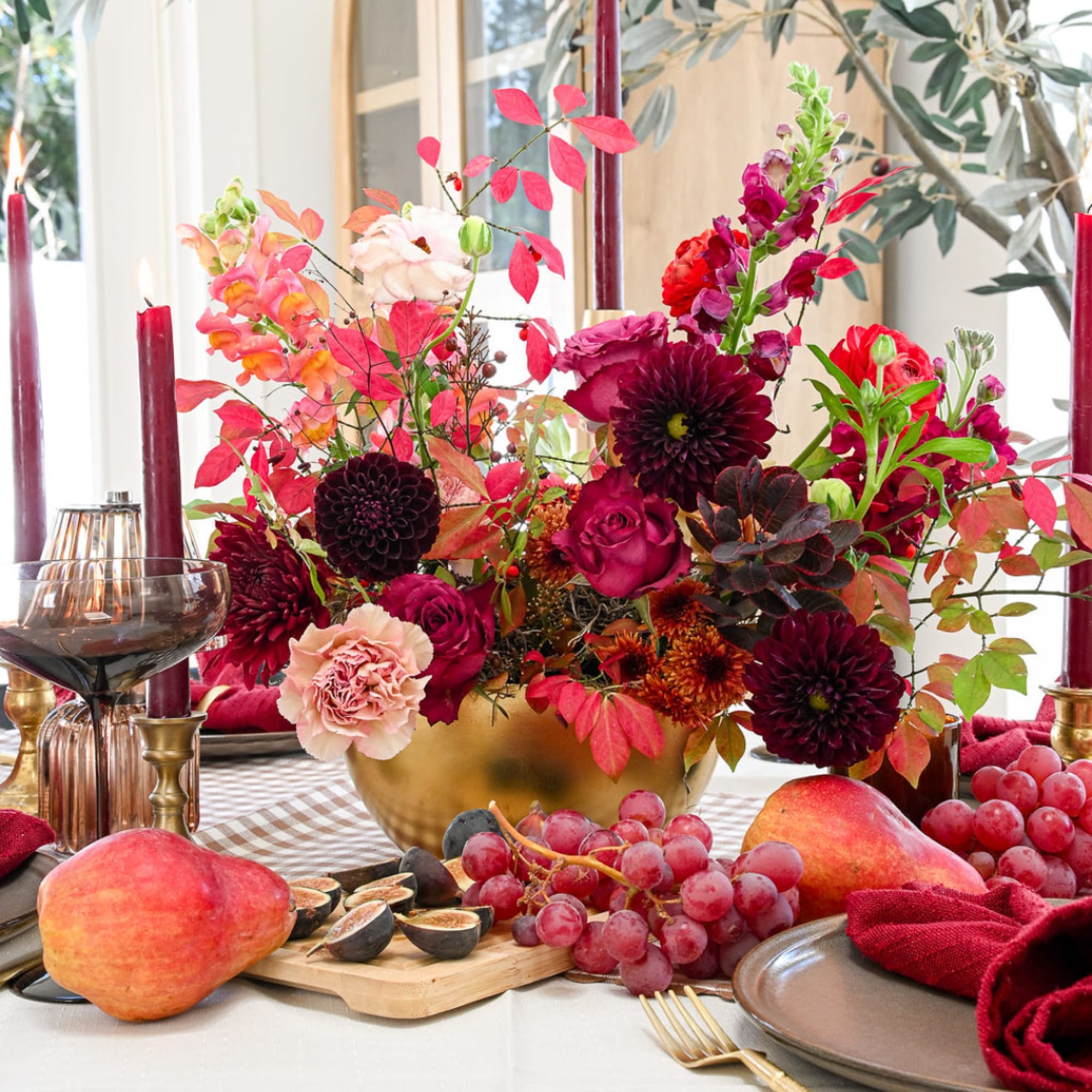Autumn floral centerpiece in a gold bowl with fruit and candles