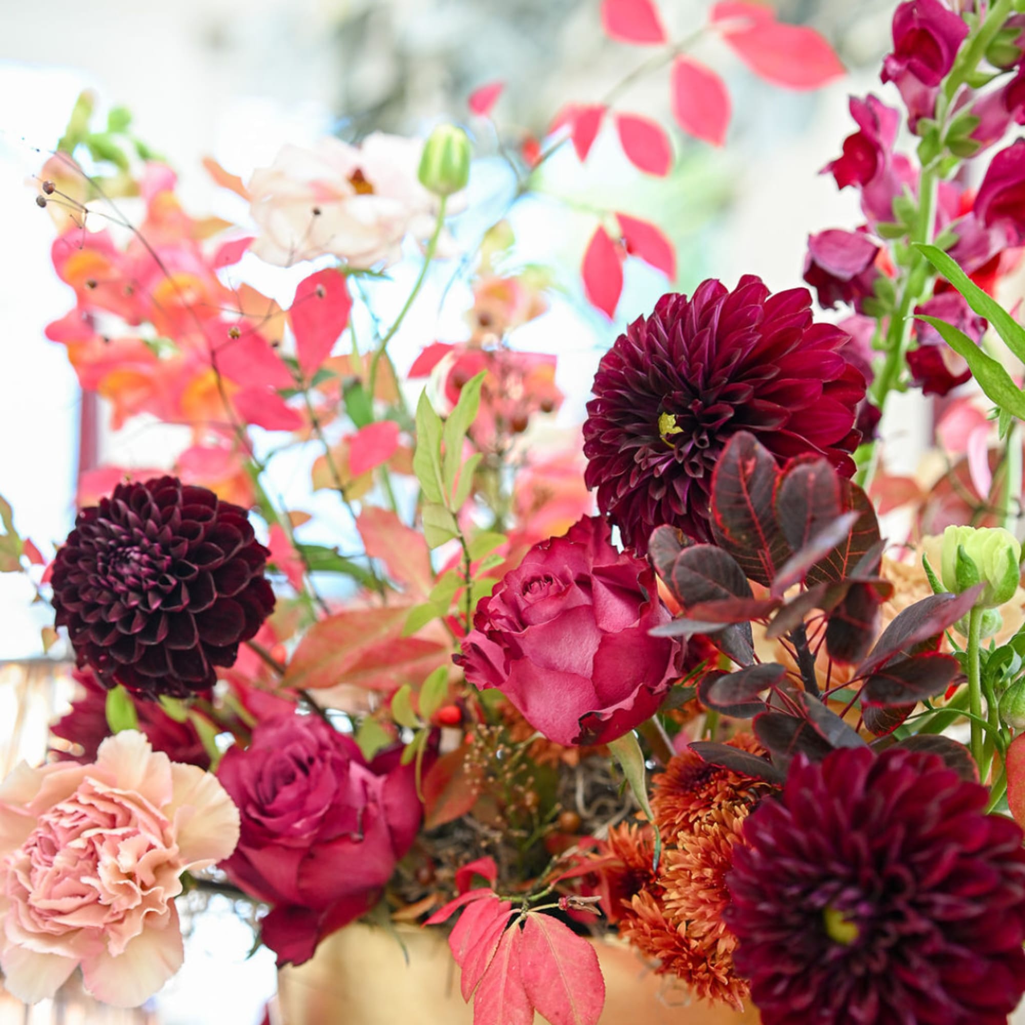 Bouquet of burgundy dahlias, pink roses, and peach carnations