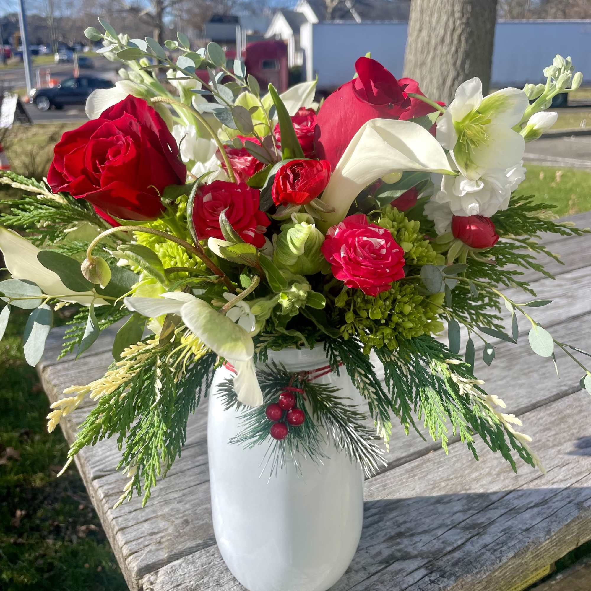 Red roses and white calla lilies in a white vase