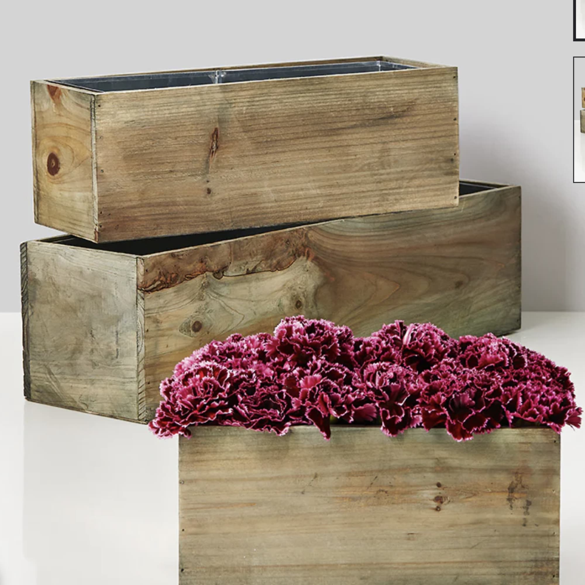 Magenta carnations arranged in a rustic wooden box