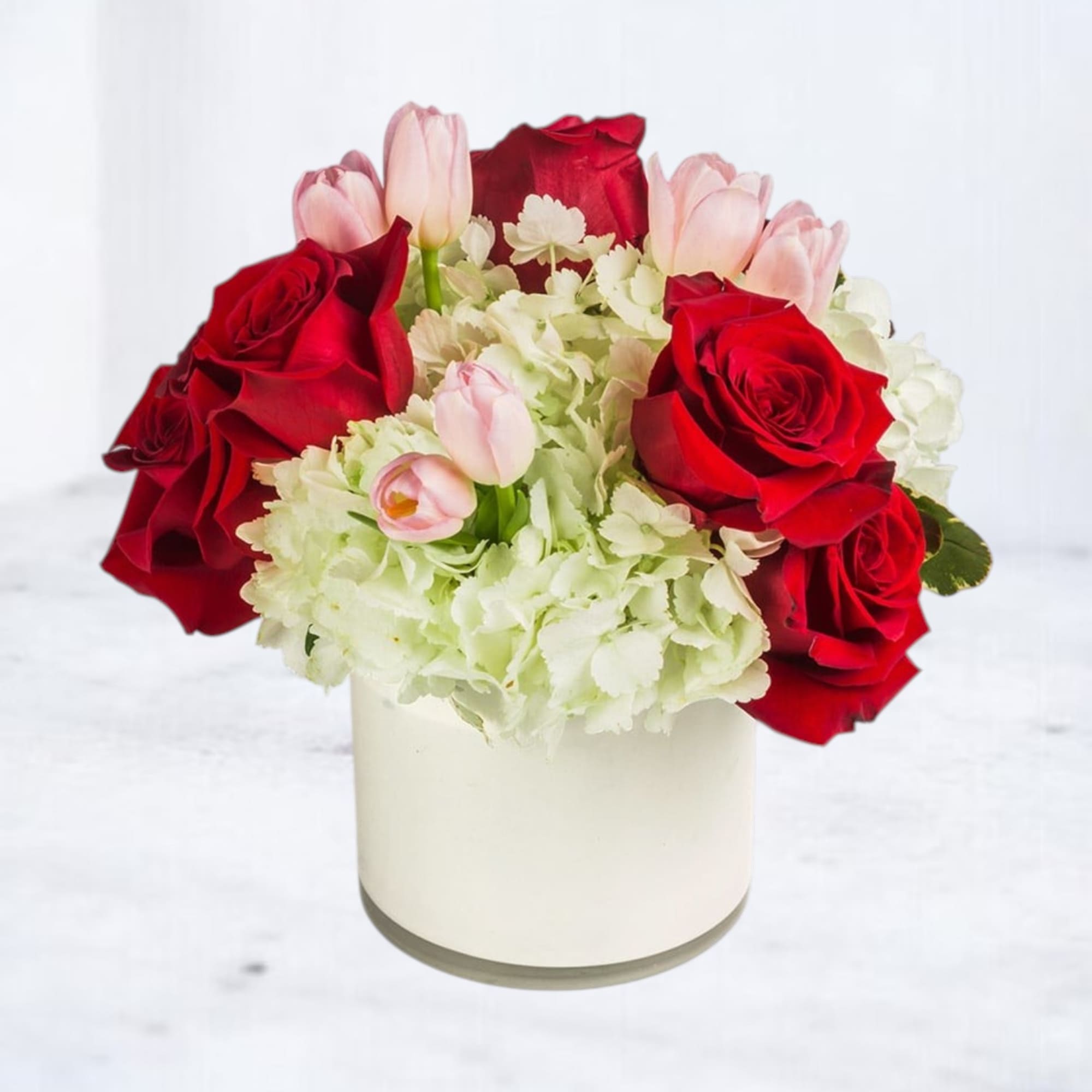 Red roses and pink tulips in a white vase