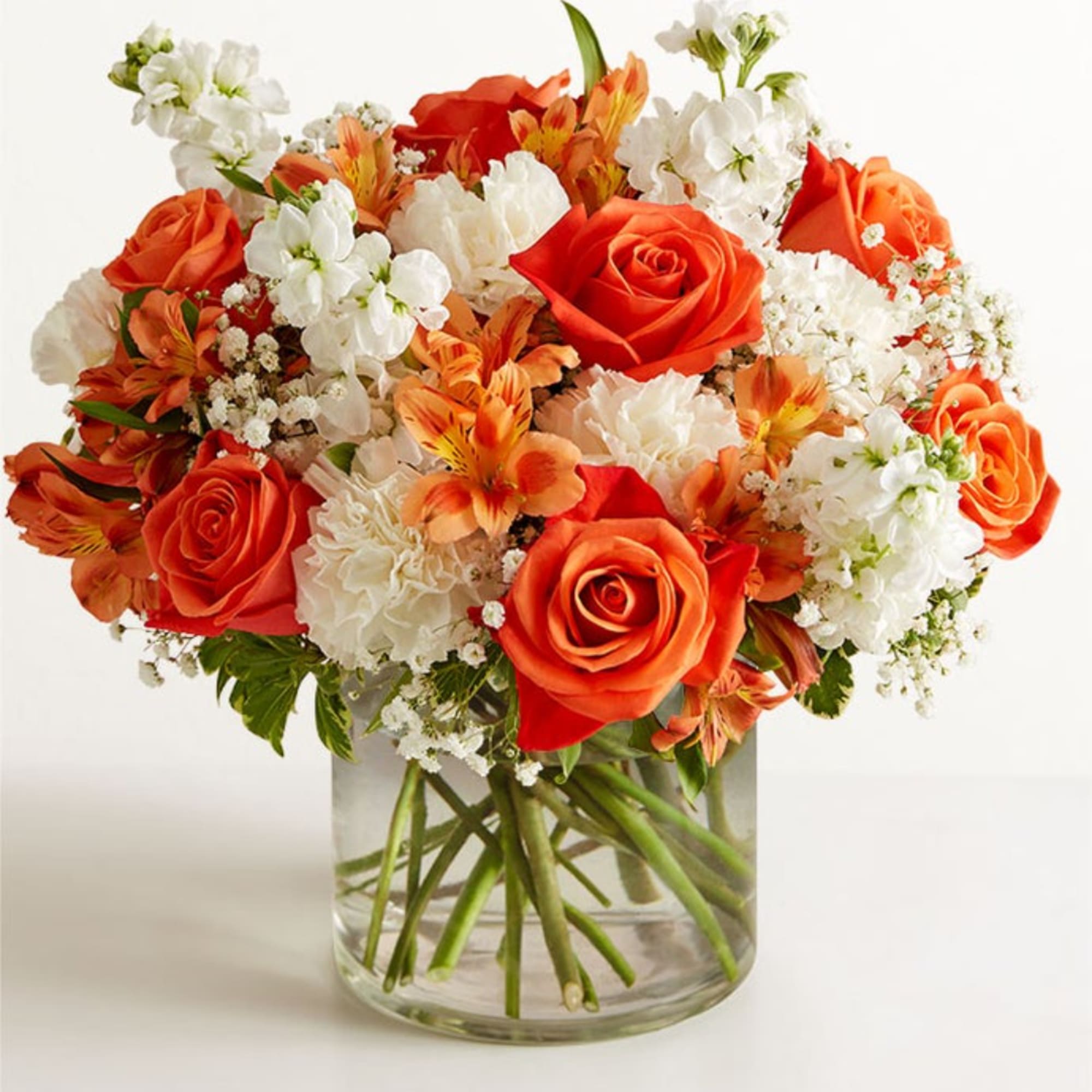 Orange and white mixed bouquet in a clear glass vase
