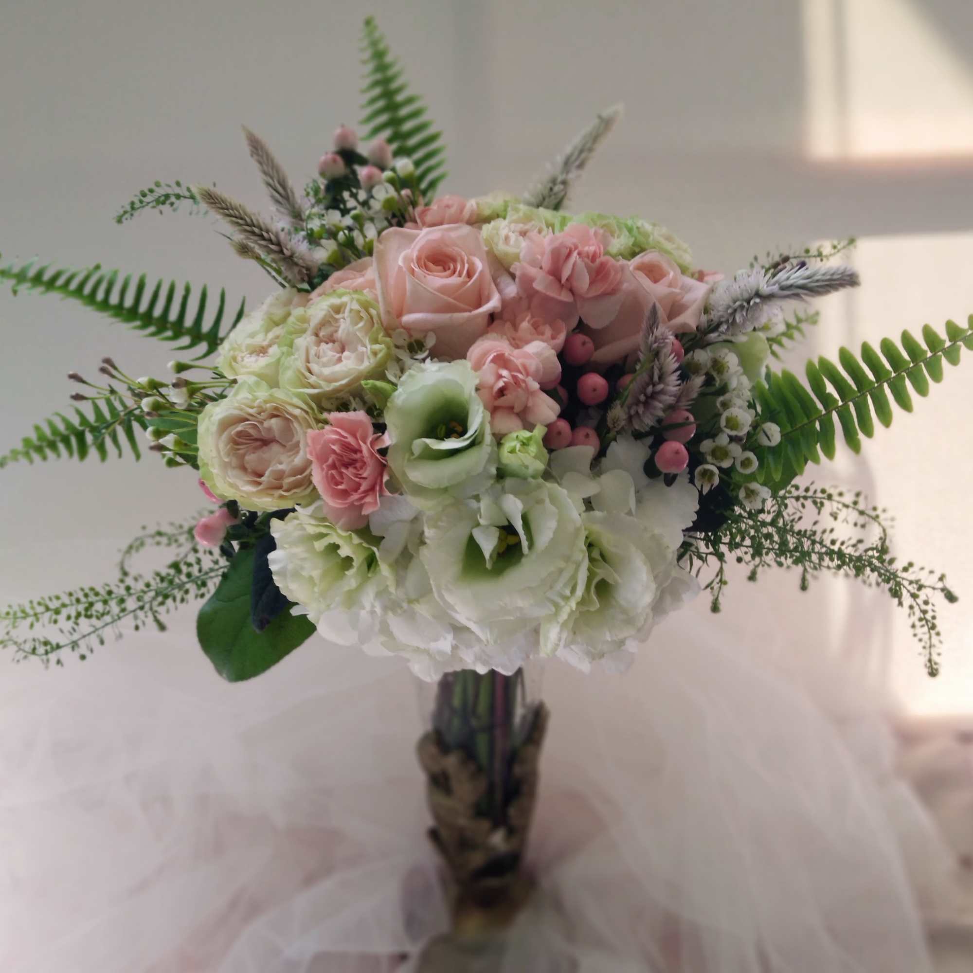 Bouquet of pink and white flowers with fern-like greenery