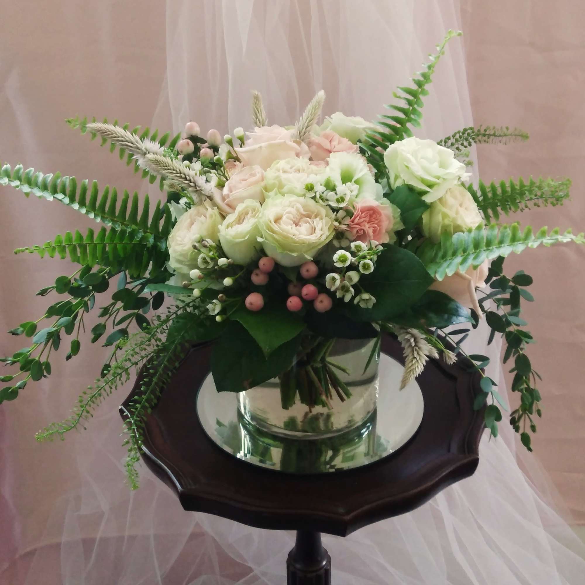 Bouquet of pale roses and greenery in a glass vase