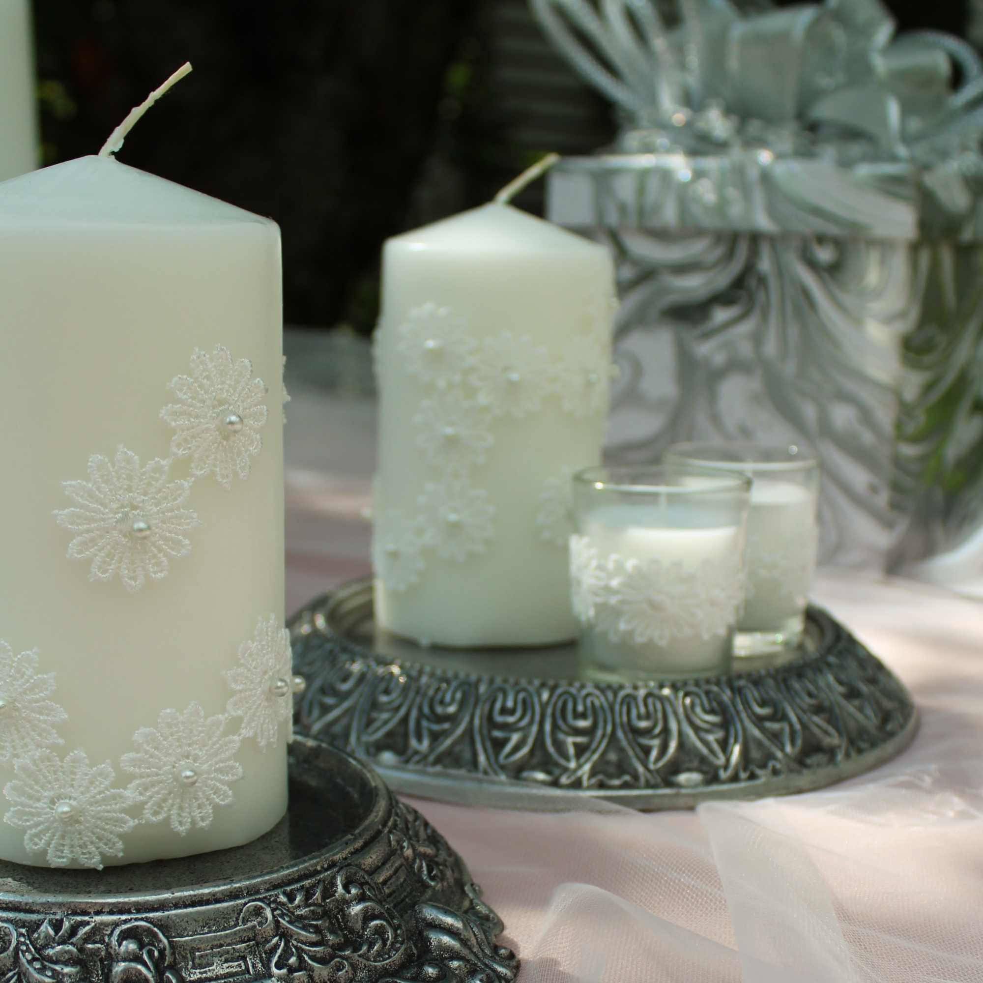 White decorative candles on ornate silver holders