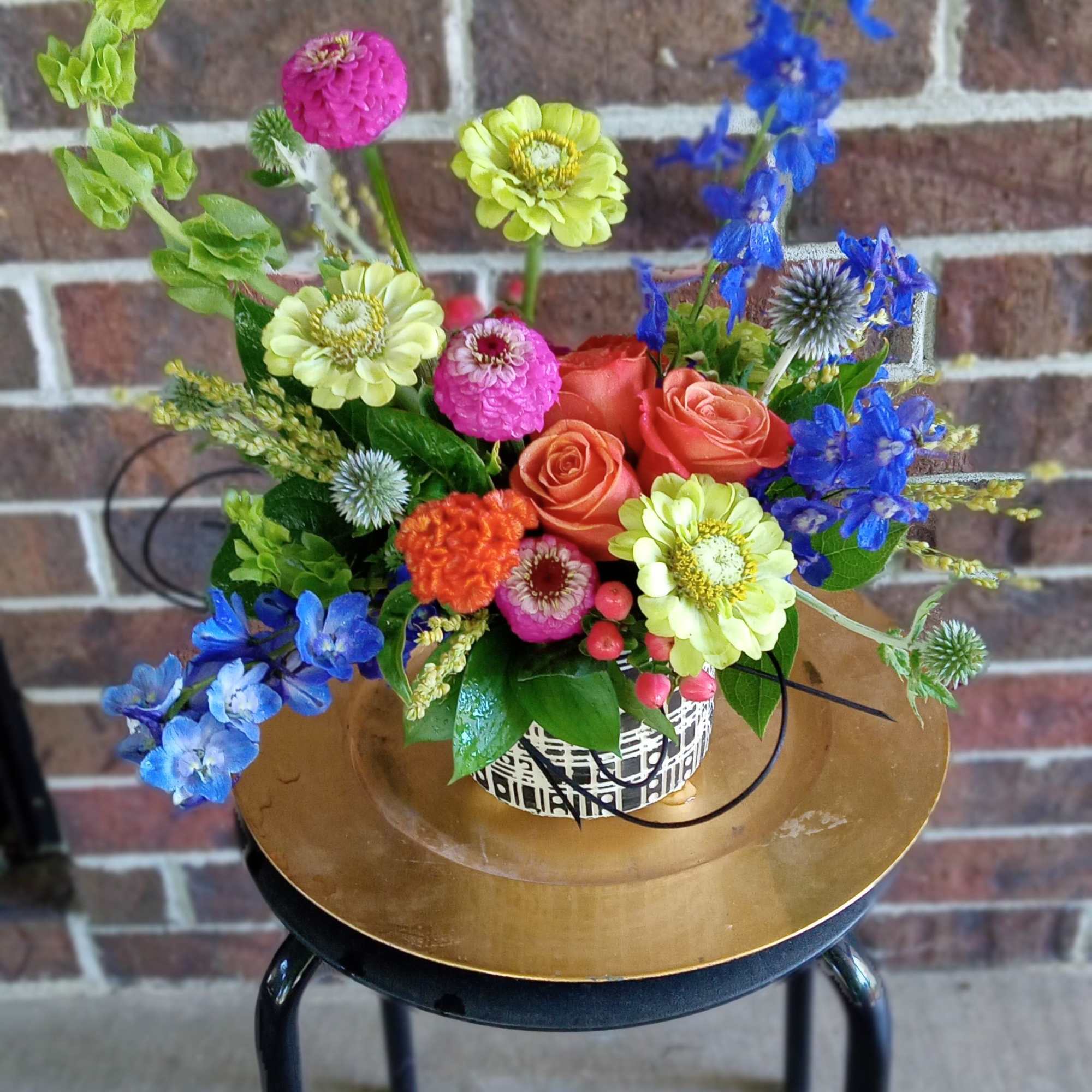 Colorful mixed flower arrangement in a patterned container