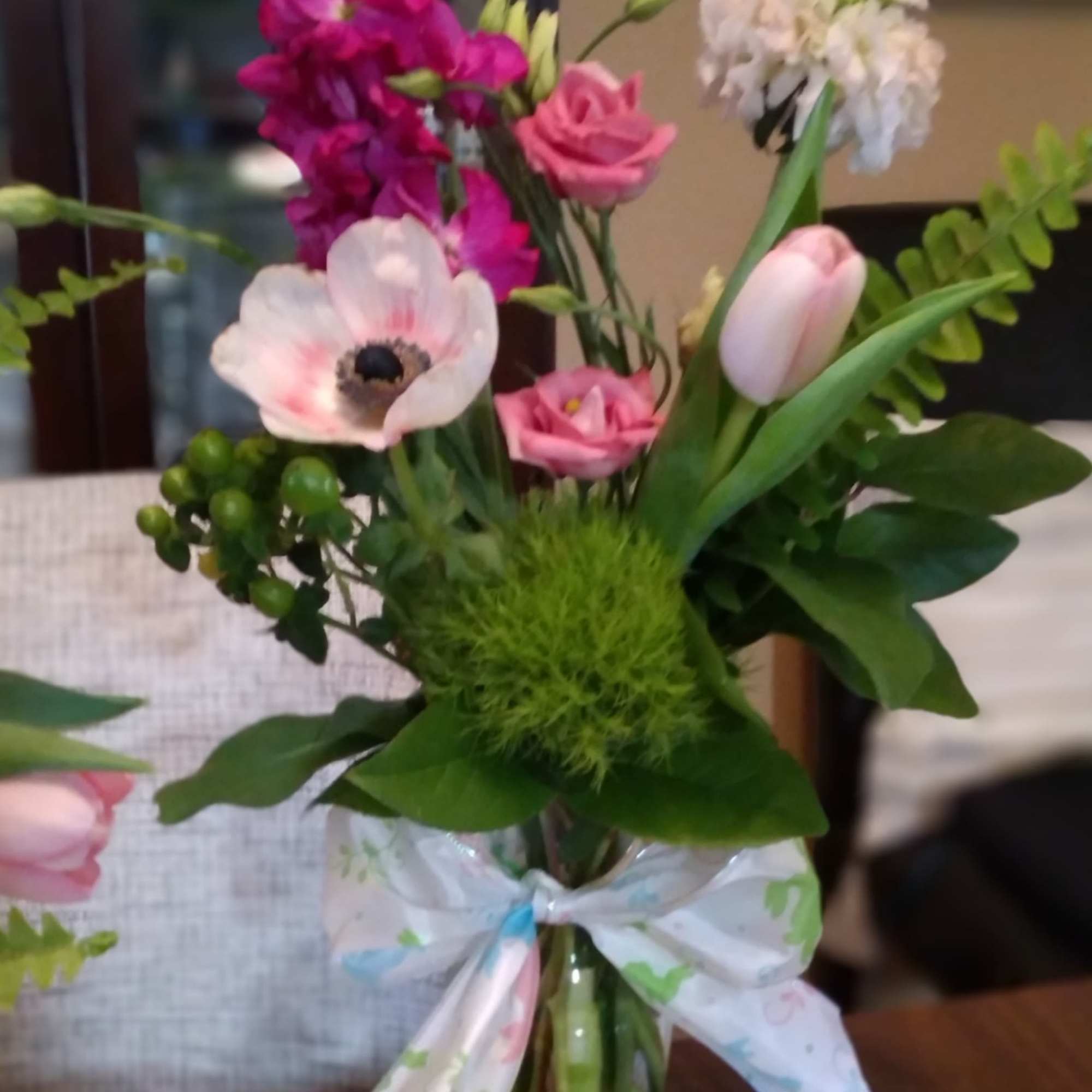 Pink and white mixed bouquet in a glass vase with a ribbon