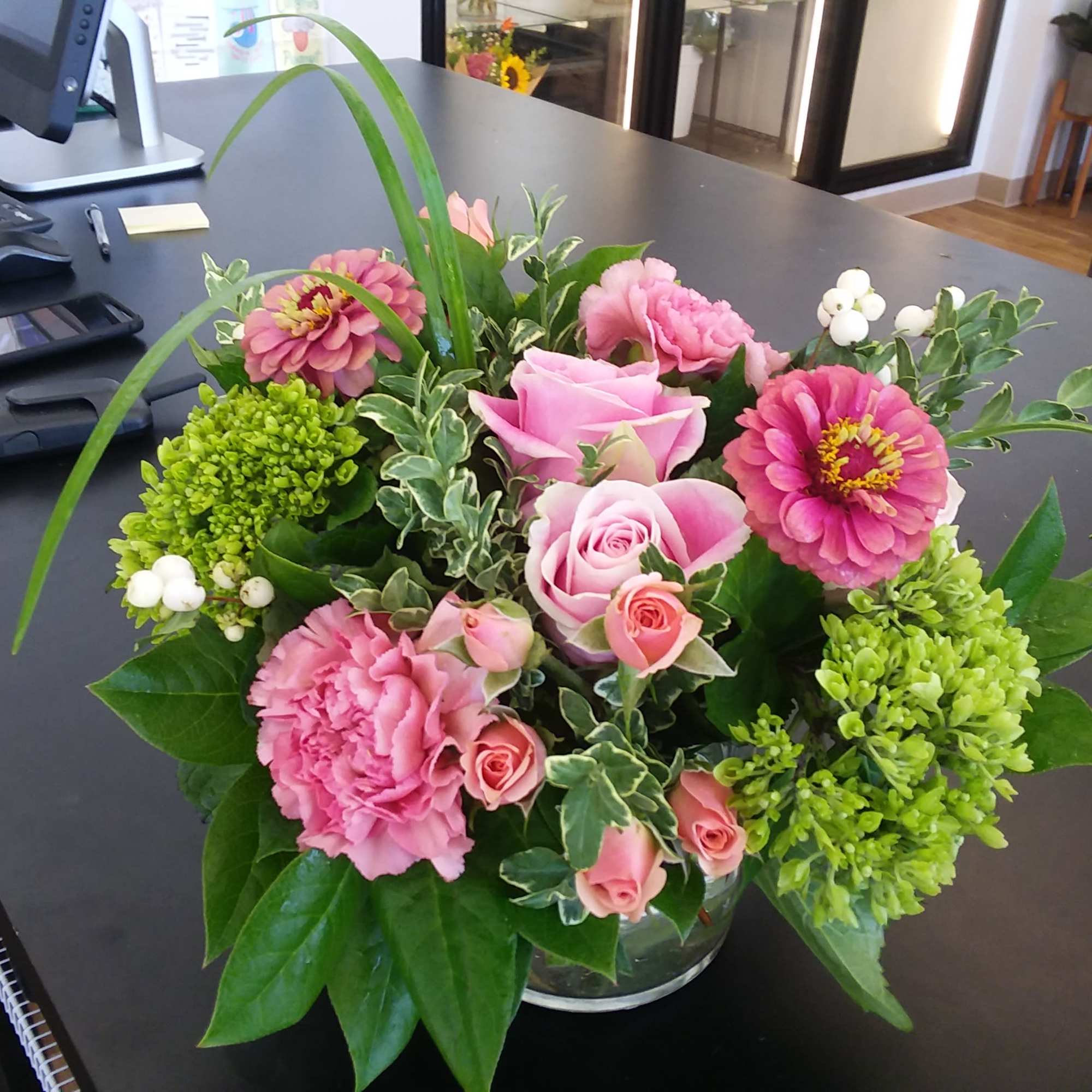 Pink and green floral arrangement in a clear glass vase