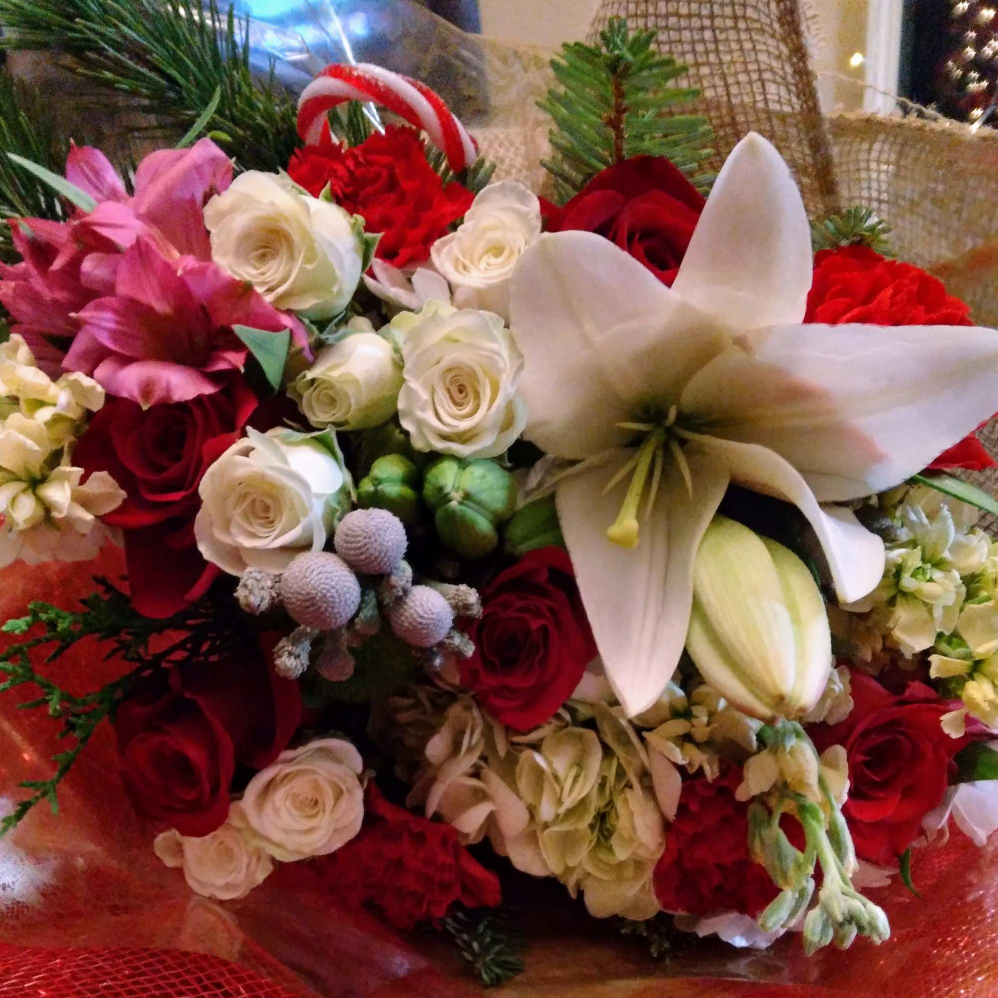 Bouquet of red and white roses with a white lily and pink flowers
