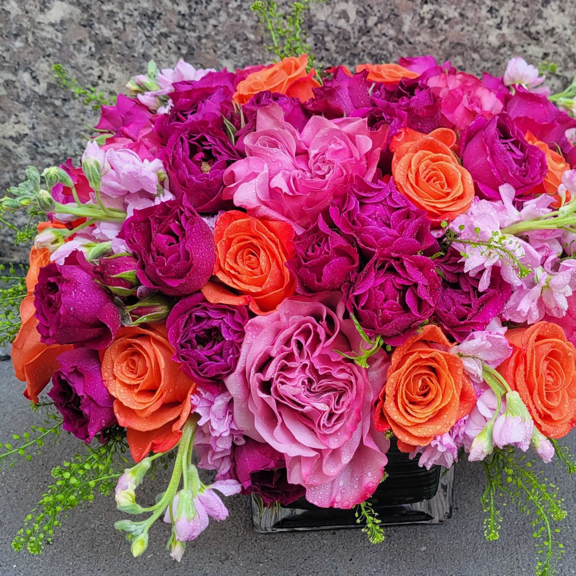 The Ruby Glow Arrangement is a stunning celebration of vibrant colors that
