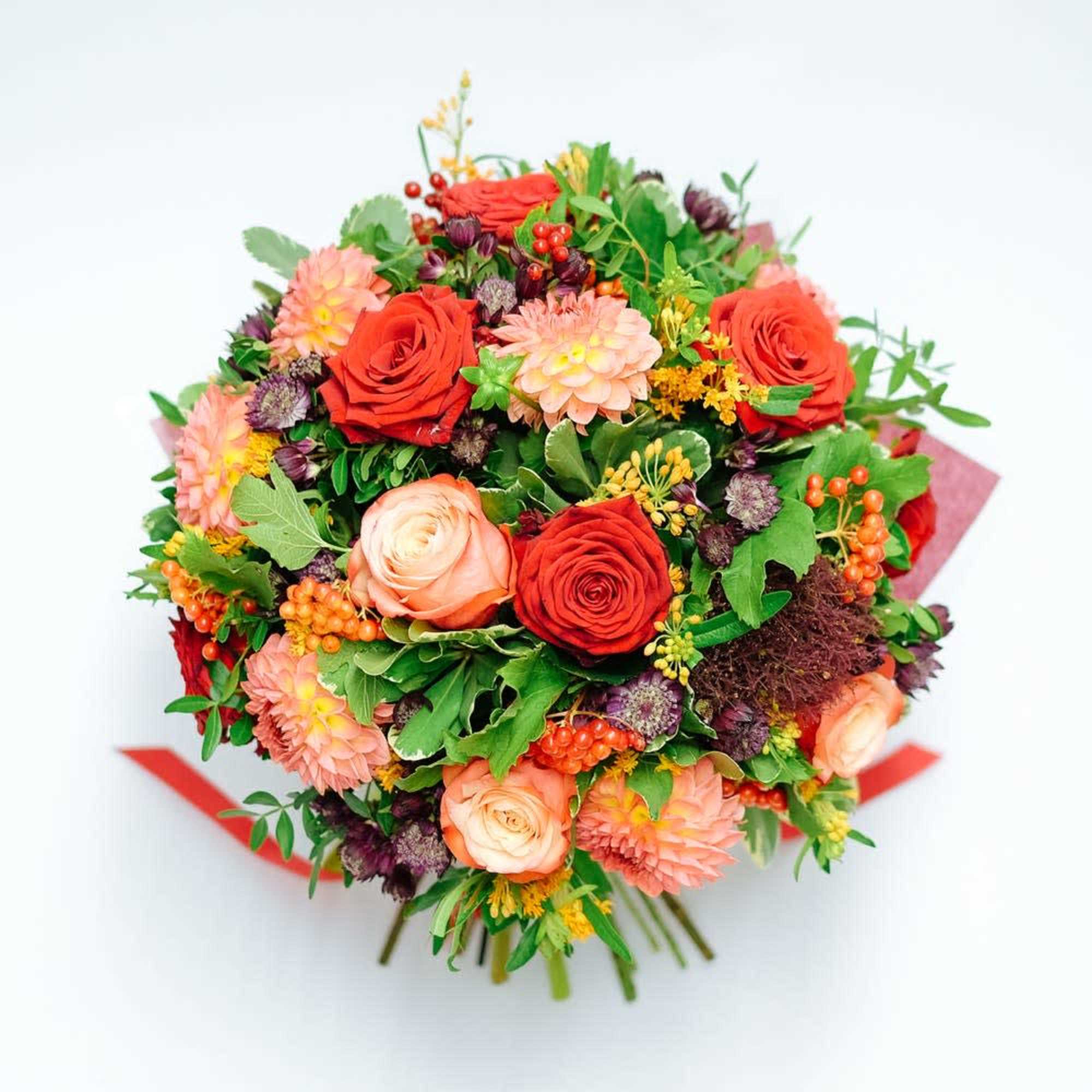A delicious round bouquet of orange blooms of Roses, Dahlia and seasonal