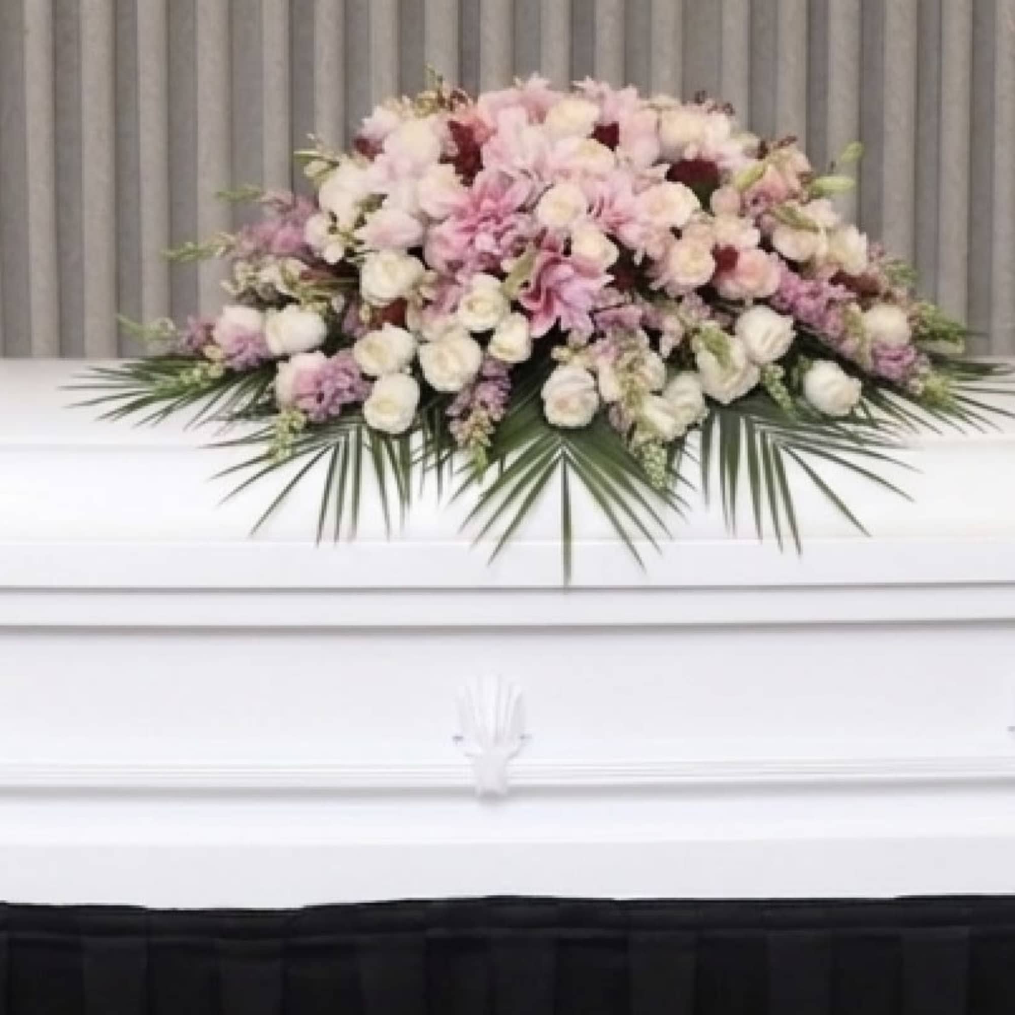 This casket spray is made with pink lilies and a variety of