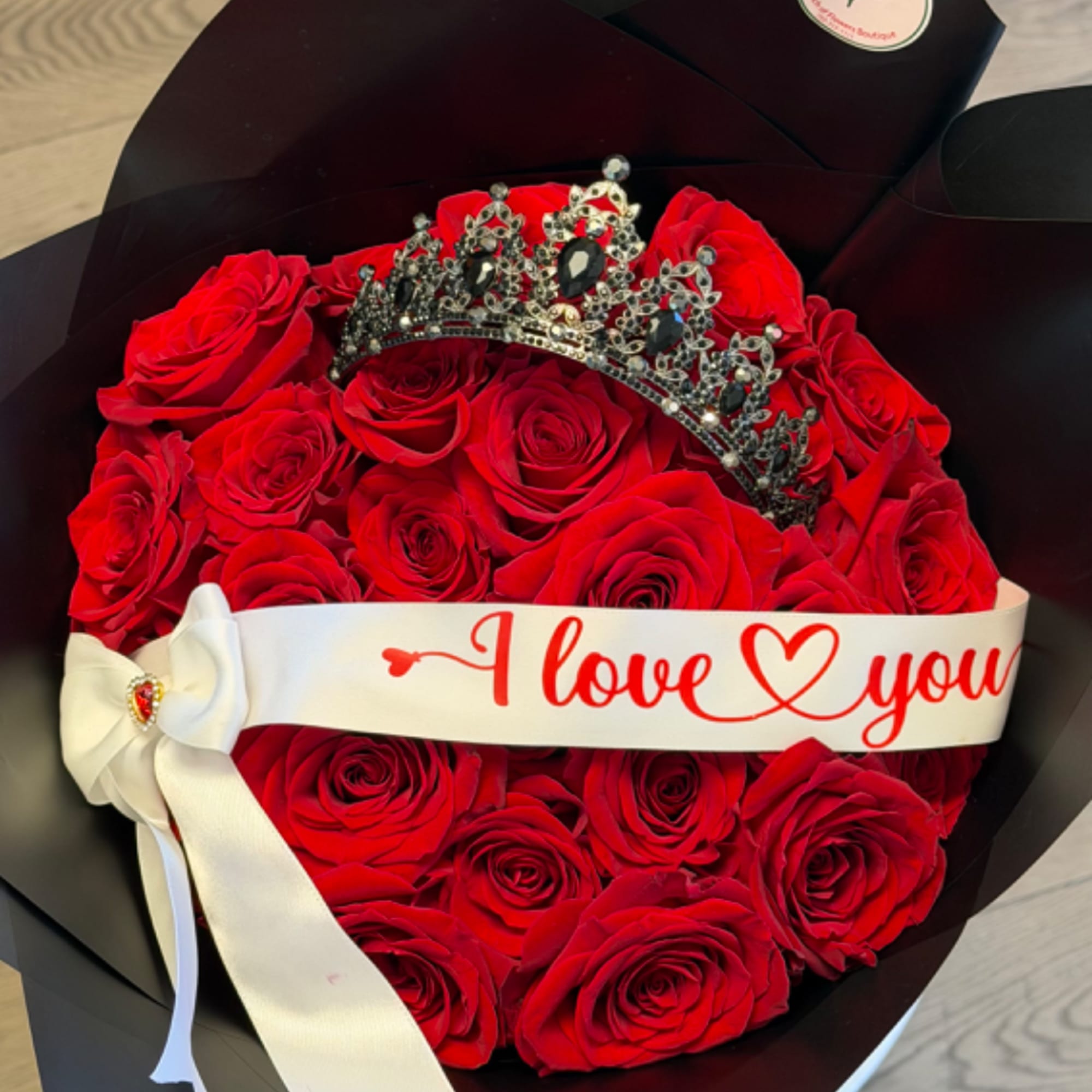 Red rose bouquet with a jeweled crown and an "I love you" ribbon