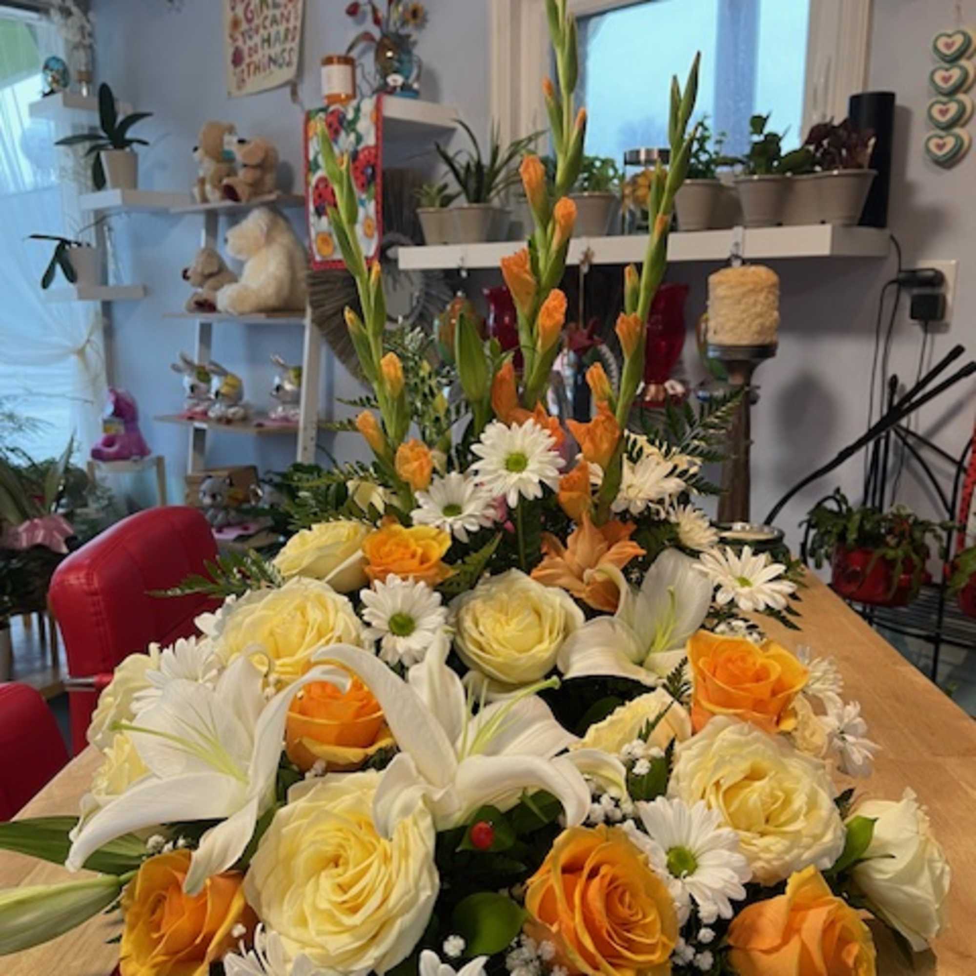 Large floral arrangement with white lilies, cream and orange roses, and white daisies